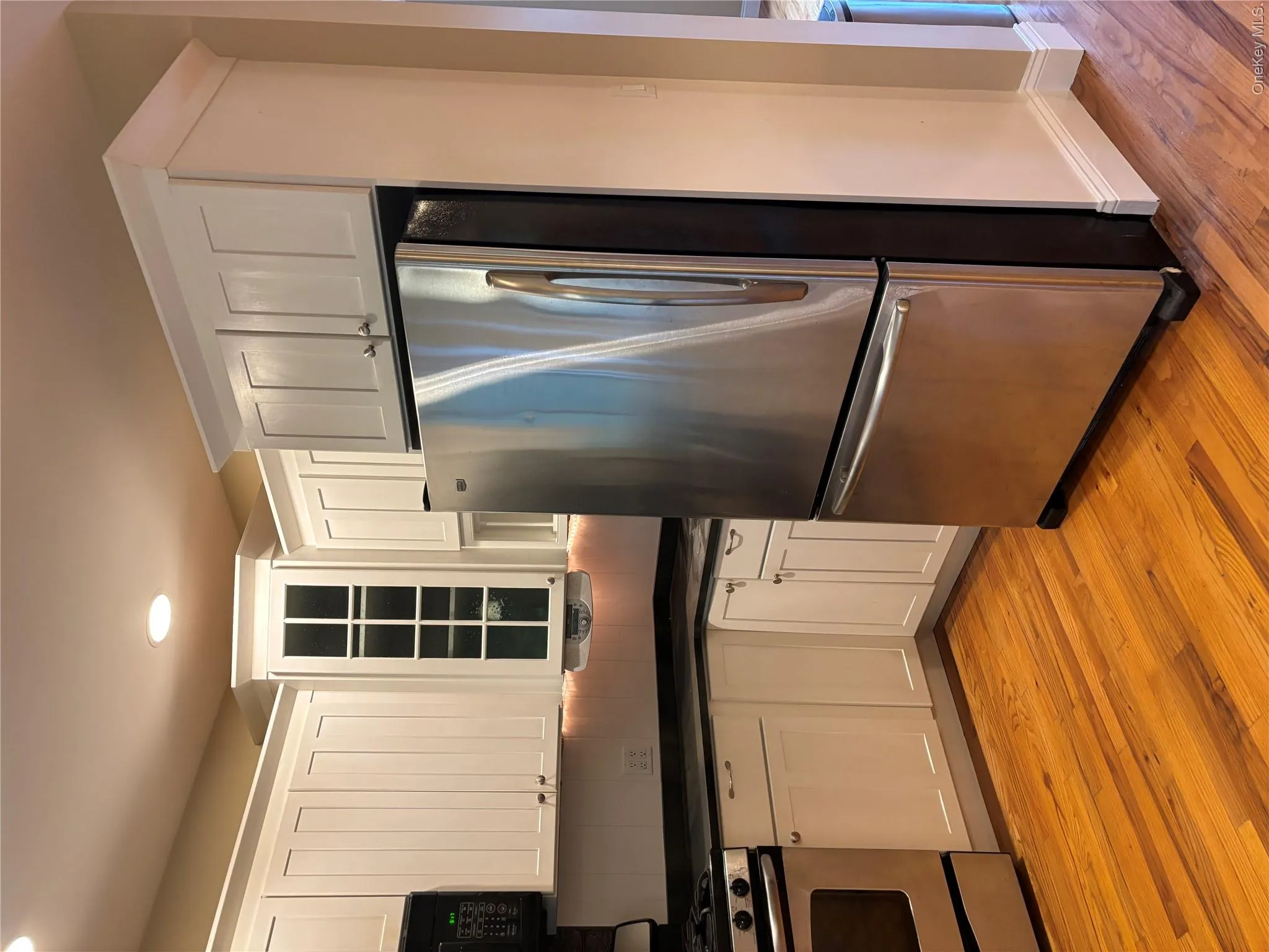 Newly updated kitchen featuring white cabinetry with raised-panel doors, stainless steel French-door refrigerator, black-topped gas range Newly updated kitchen featuring white cabinetry with raised-panel doors, stainless steel French-door refrigerator, black-topped gas range