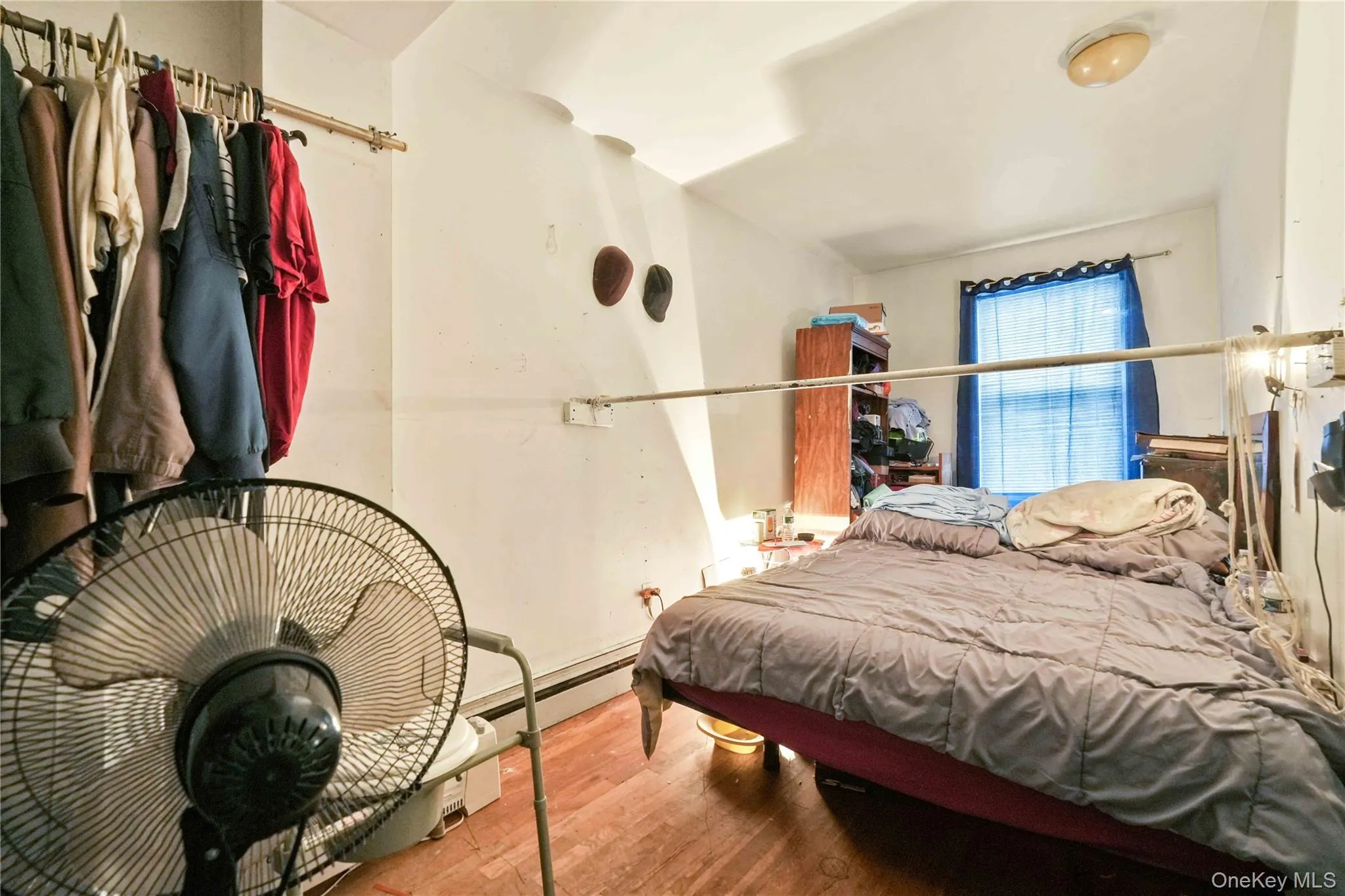 Hardwood flooring, window with blue drapery, and overhead lighting Hardwood flooring, window with blue drapery, and overhead lighting