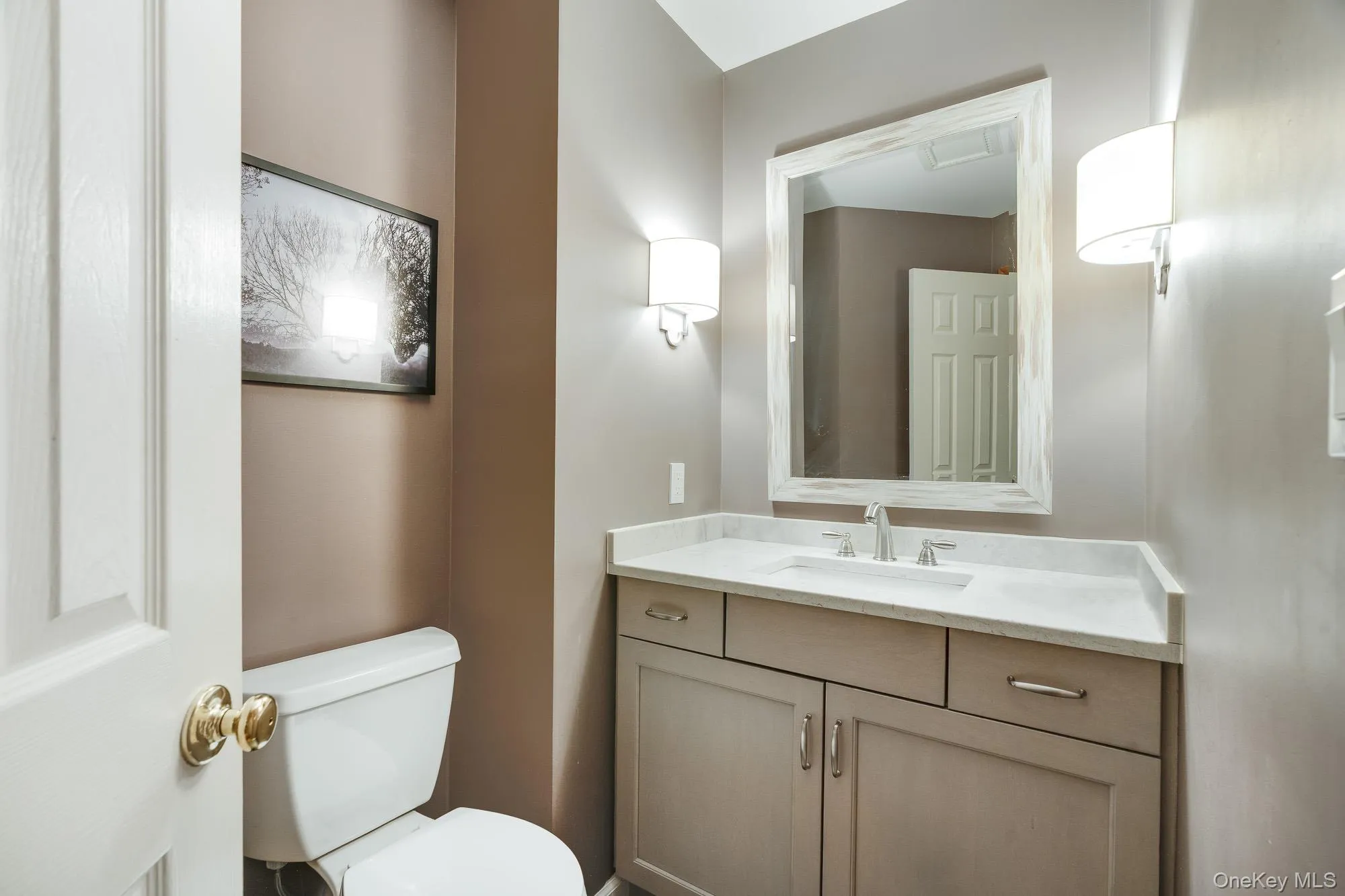 Half bath featuring vanity and toilet Half bath featuring vanity and toilet