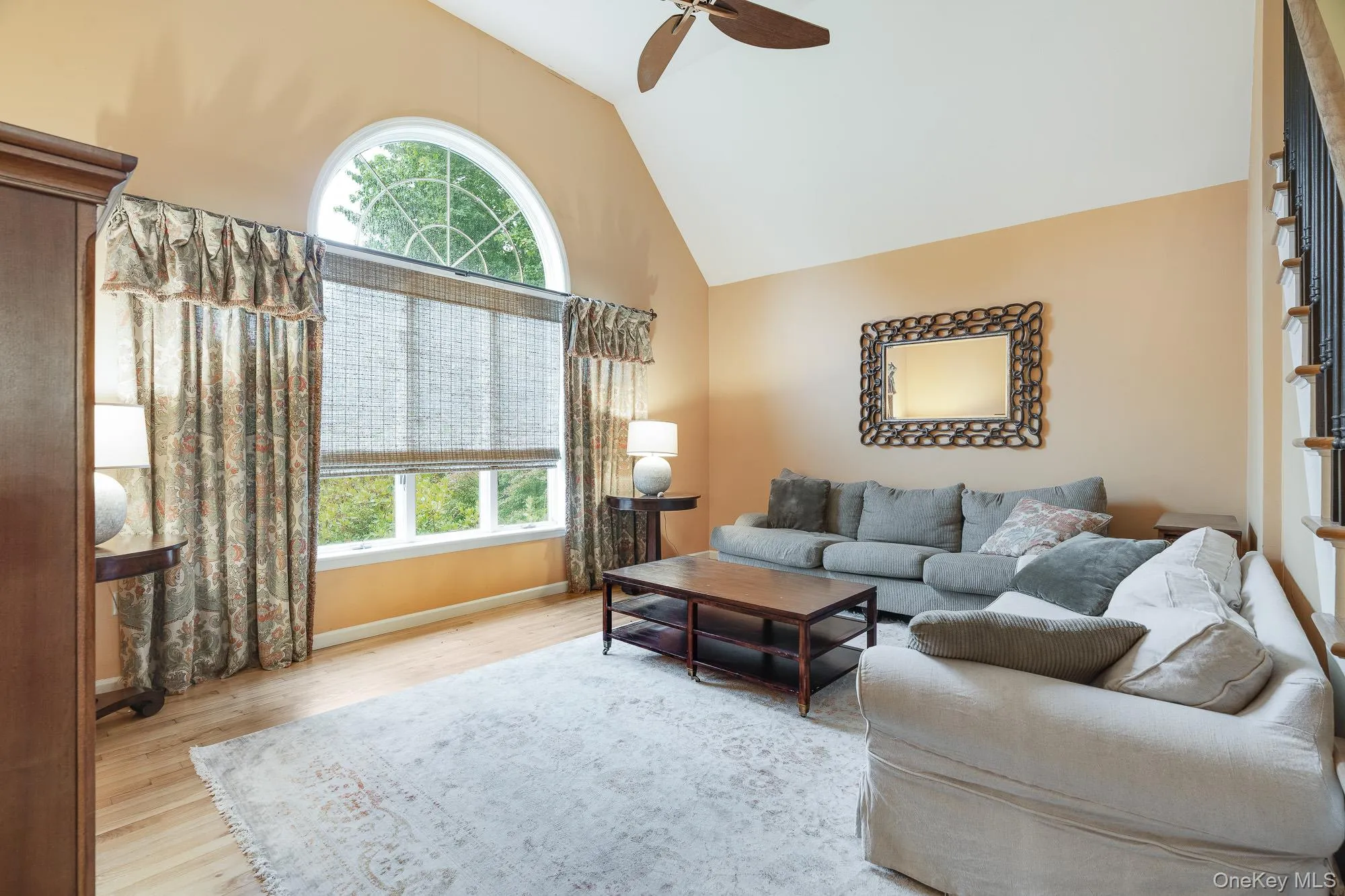 Living area with vaulted ceiling, wood finished floors, and ceiling fan Living area with vaulted ceiling, wood finished floors, and ceiling fan