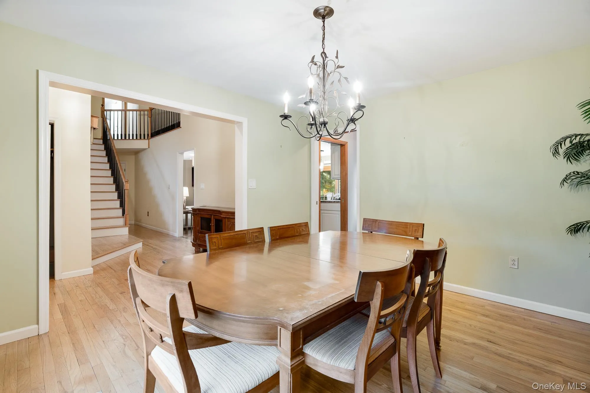 Dining space featuring light wood-style flooring, stairway, and a chandelier Dining space featuring light wood-style flooring, stairway, and a chandelier
