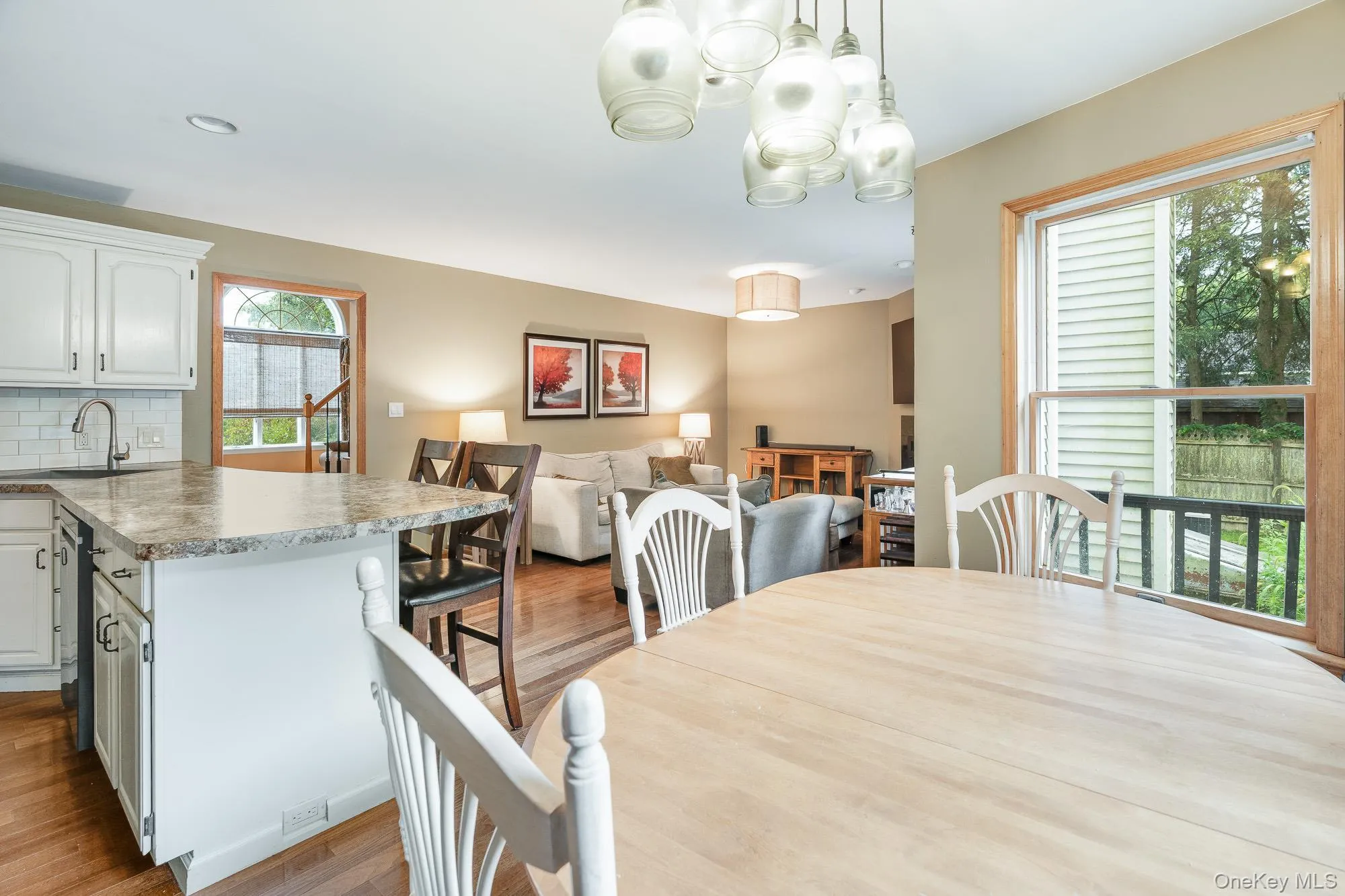 Dining area featuring light wood-type flooring, plenty of natural light, and a chandelier Dining area featuring light wood-type flooring, plenty of natural light, and a chandelier