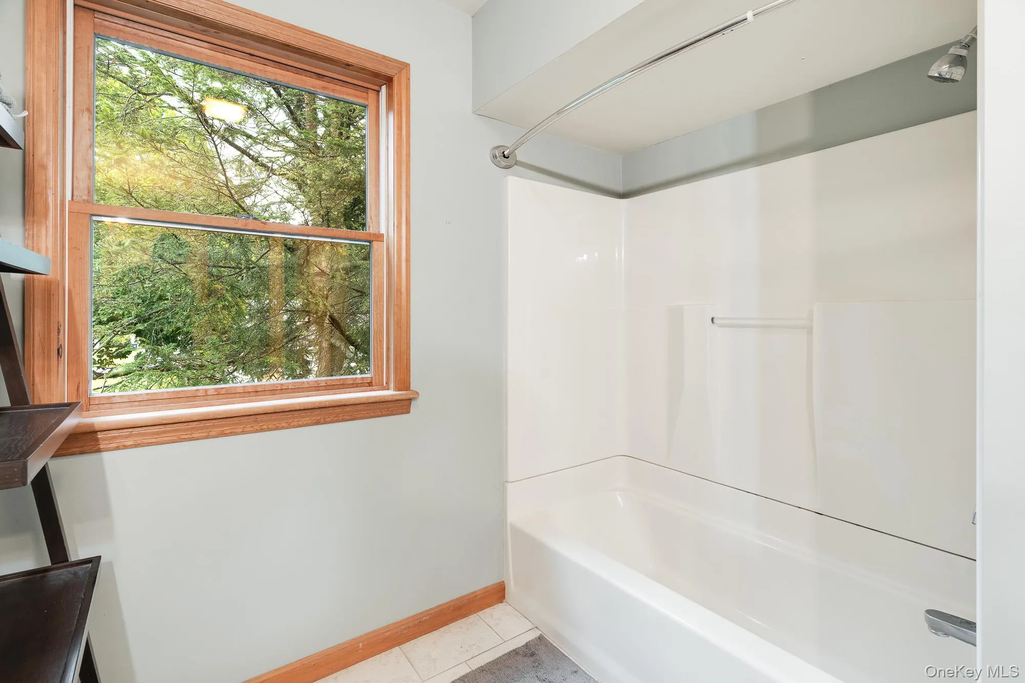 Bathroom with light tile patterned floors and shower / washtub combination Bathroom with light tile patterned floors and shower / washtub combination