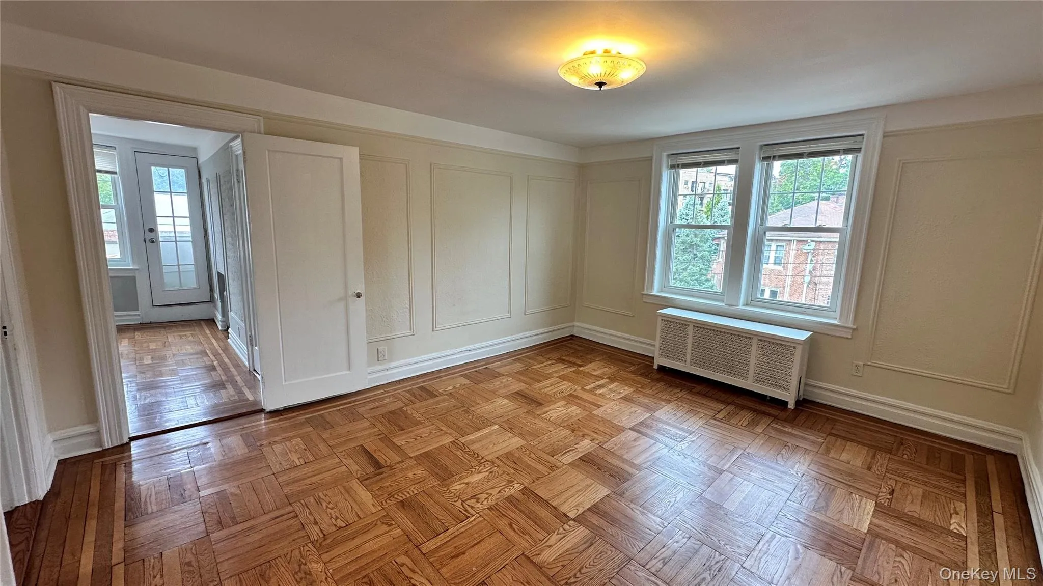 Parquet wood flooring, decorative wall molding, dual pane windows, and a ceiling-mounted light fixture Parquet wood flooring, decorative wall molding, dual pane windows, and a ceiling-mounted light fixture