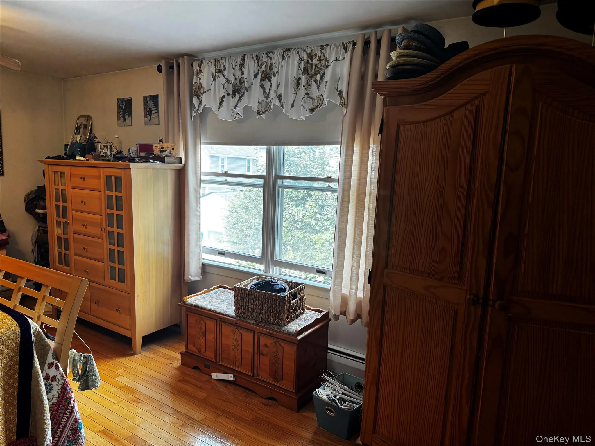 Hardwood flooring, window with sash detail, and baseboard heating Hardwood flooring, window with sash detail, and baseboard heating