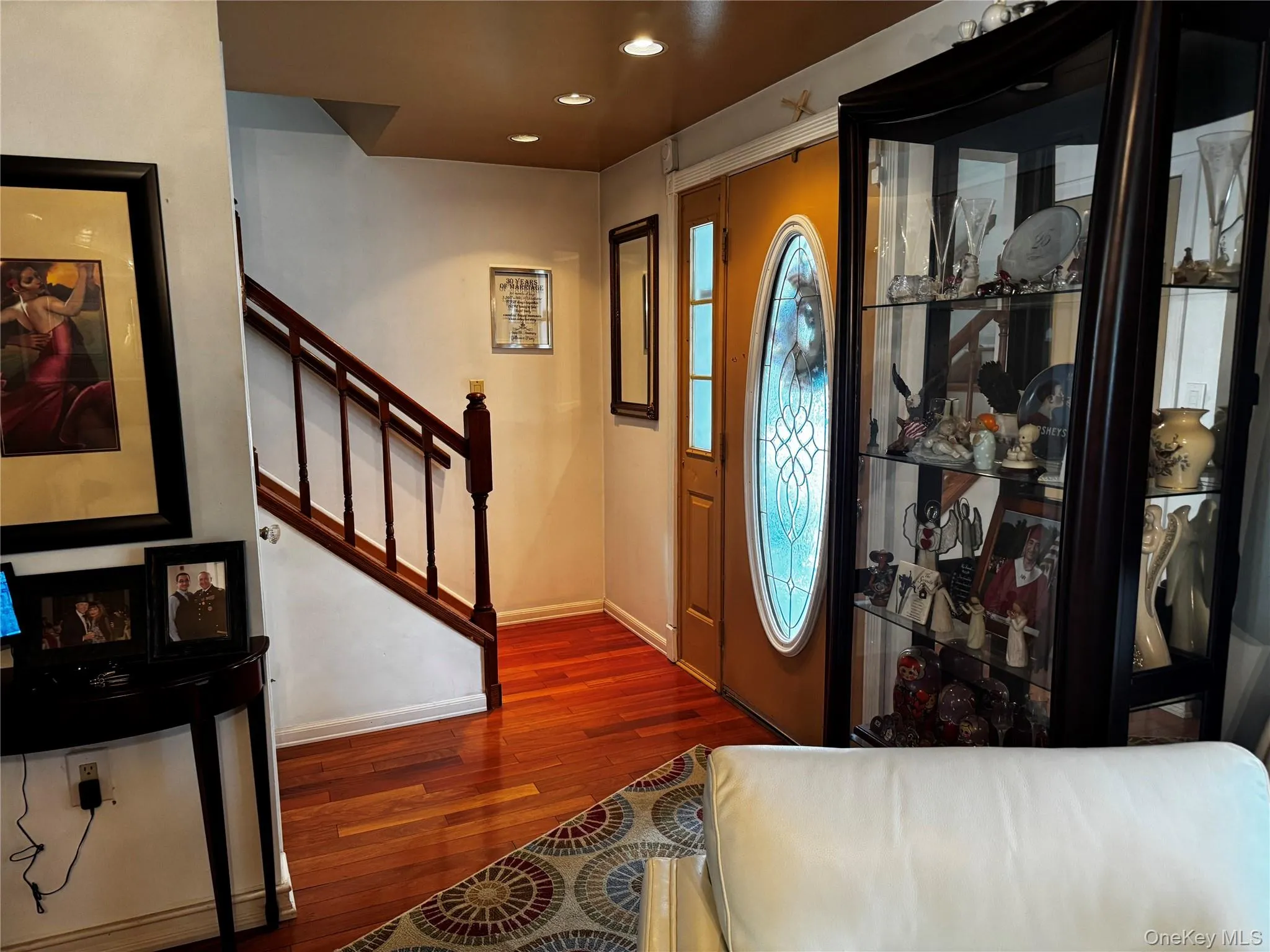 Hardwood flooring, recessed lighting, and a wood staircase with balusters Hardwood flooring, recessed lighting, and a wood staircase with balusters