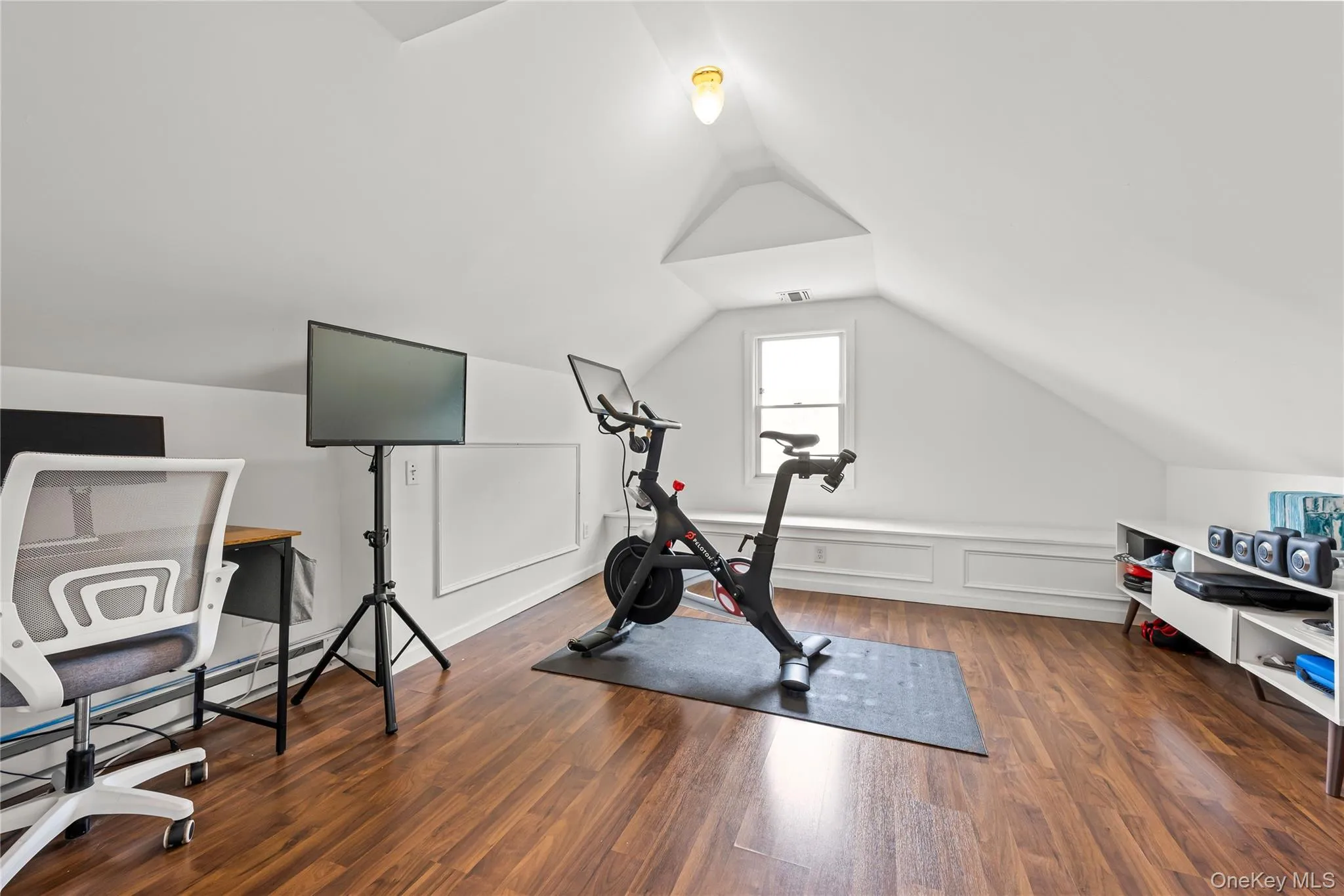 Attic space featuring wood-finish flooring, vaulted ceiling, built-in window bench, and a dormer window Attic space featuring wood-finish flooring, vaulted ceiling, built-in window bench, and a dormer window