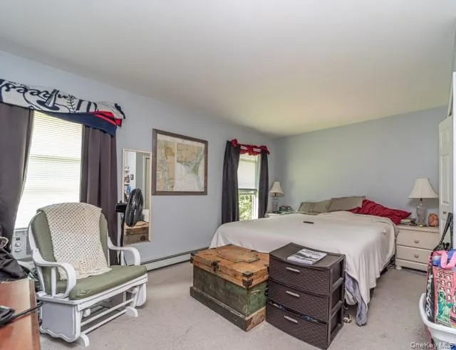 Carpeted room featuring light blue walls, two windows with blinds, and white trim Carpeted room featuring light blue walls, two windows with blinds, and white trim