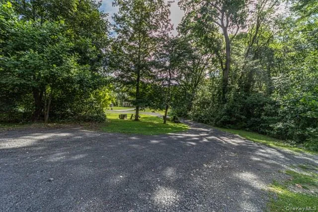 Gravel driveway with abundant mature trees and natural landscaping Gravel driveway with abundant mature trees and natural landscaping
