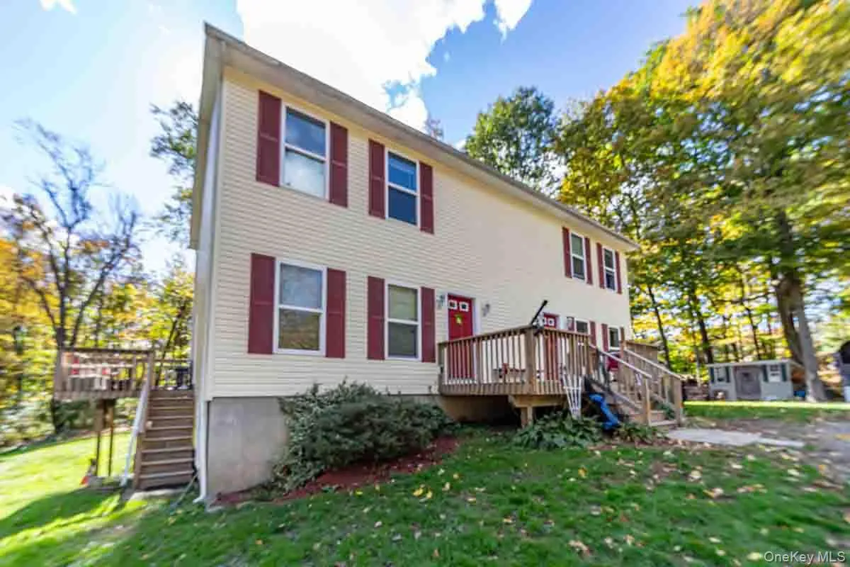 Two-story exterior with light-colored siding and red shutters Two-story exterior with light-colored siding and red shutters