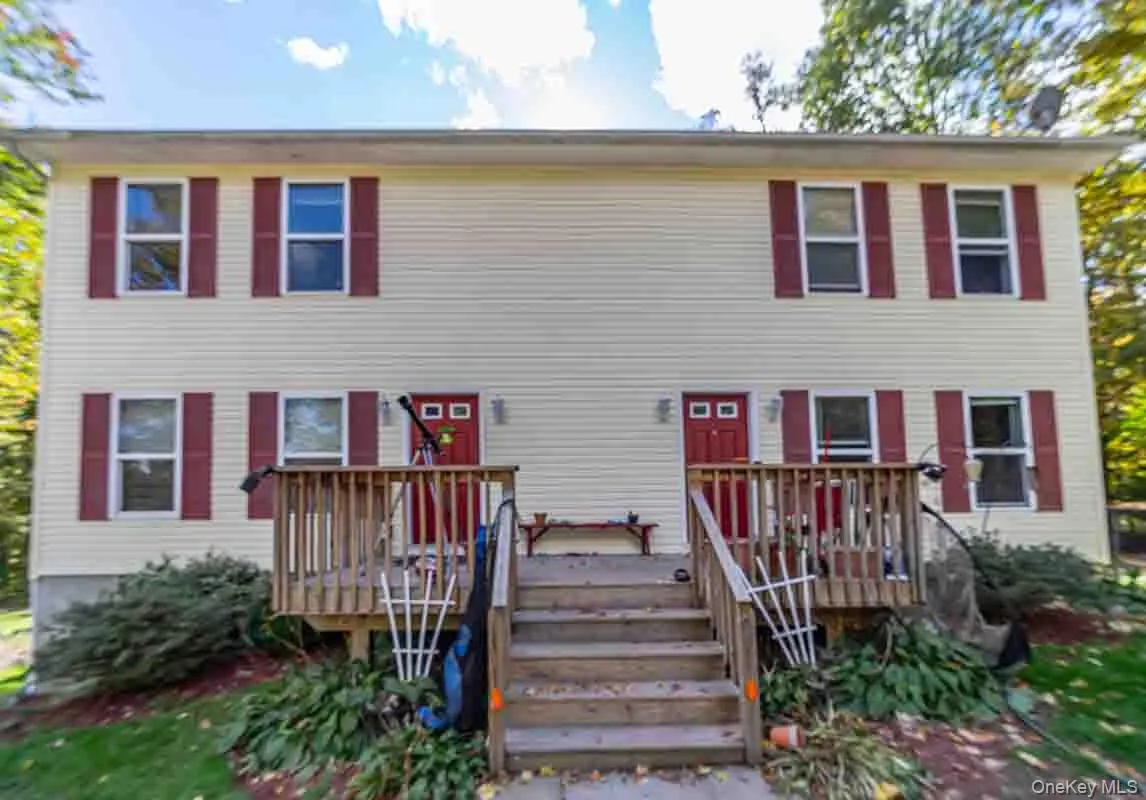Two-story exterior with light-colored siding and red shutters Two-story exterior with light-colored siding and red shutters
