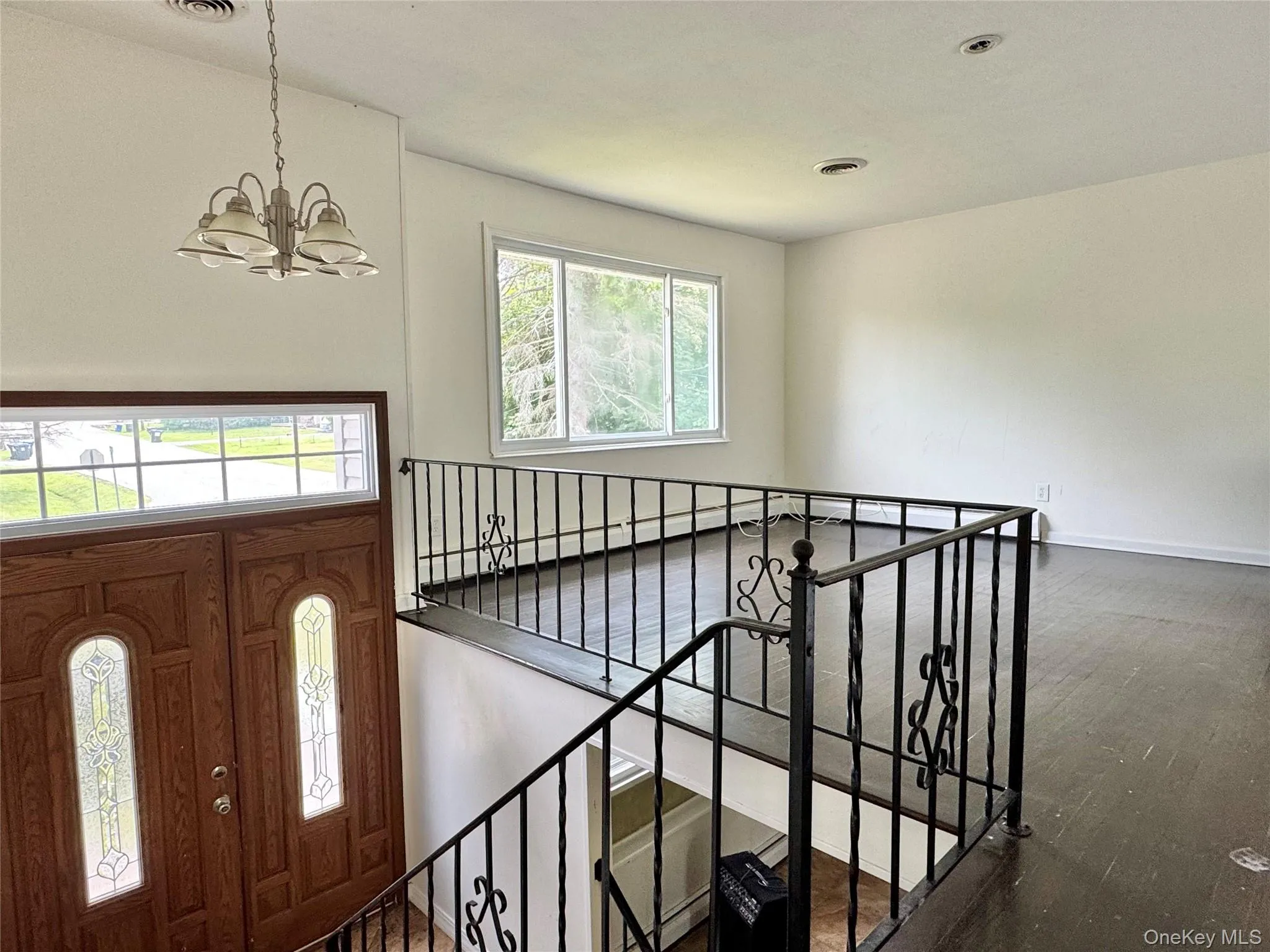 Foyer with a chandelier and wood finished floors Foyer with a chandelier and wood finished floors
