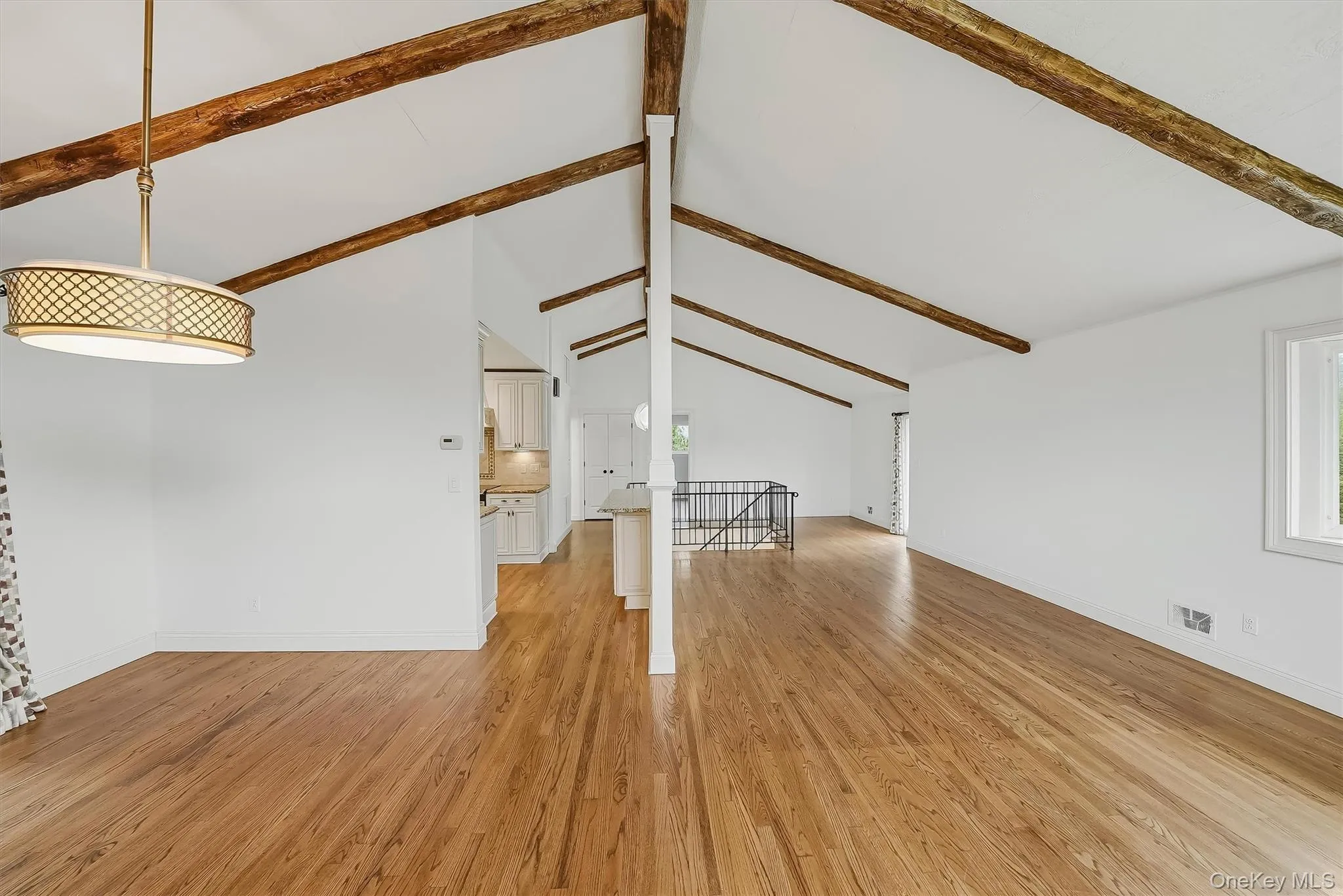 Open-plan great room w/ hardwood floors, exposed wood beams, and fresh paint. Open-plan great room w/ hardwood floors, exposed wood beams, and fresh paint.