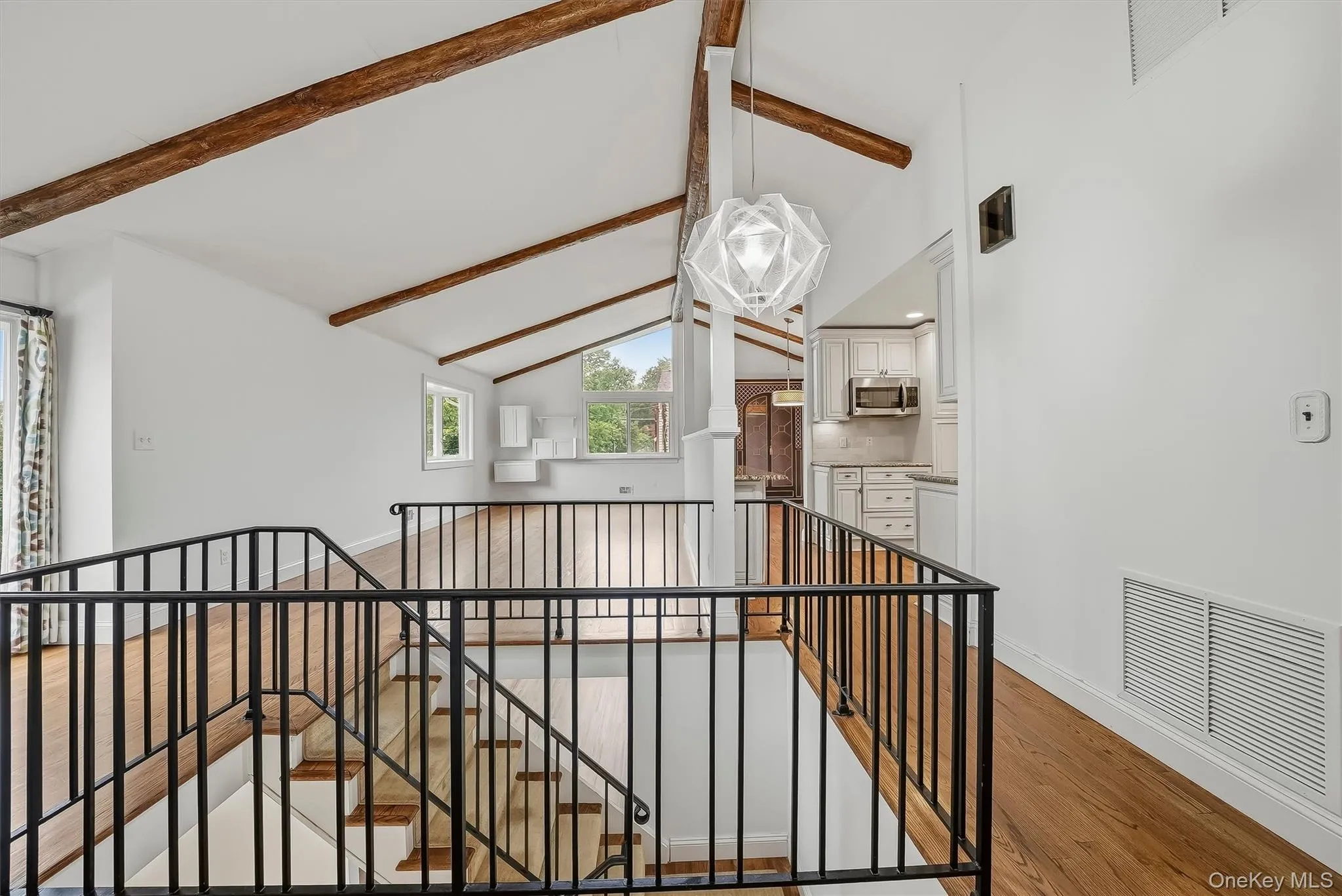 Open-plan great room w/ hardwood floors, exposed wood beams, and fresh paint. Open-plan great room w/ hardwood floors, exposed wood beams, and fresh paint.