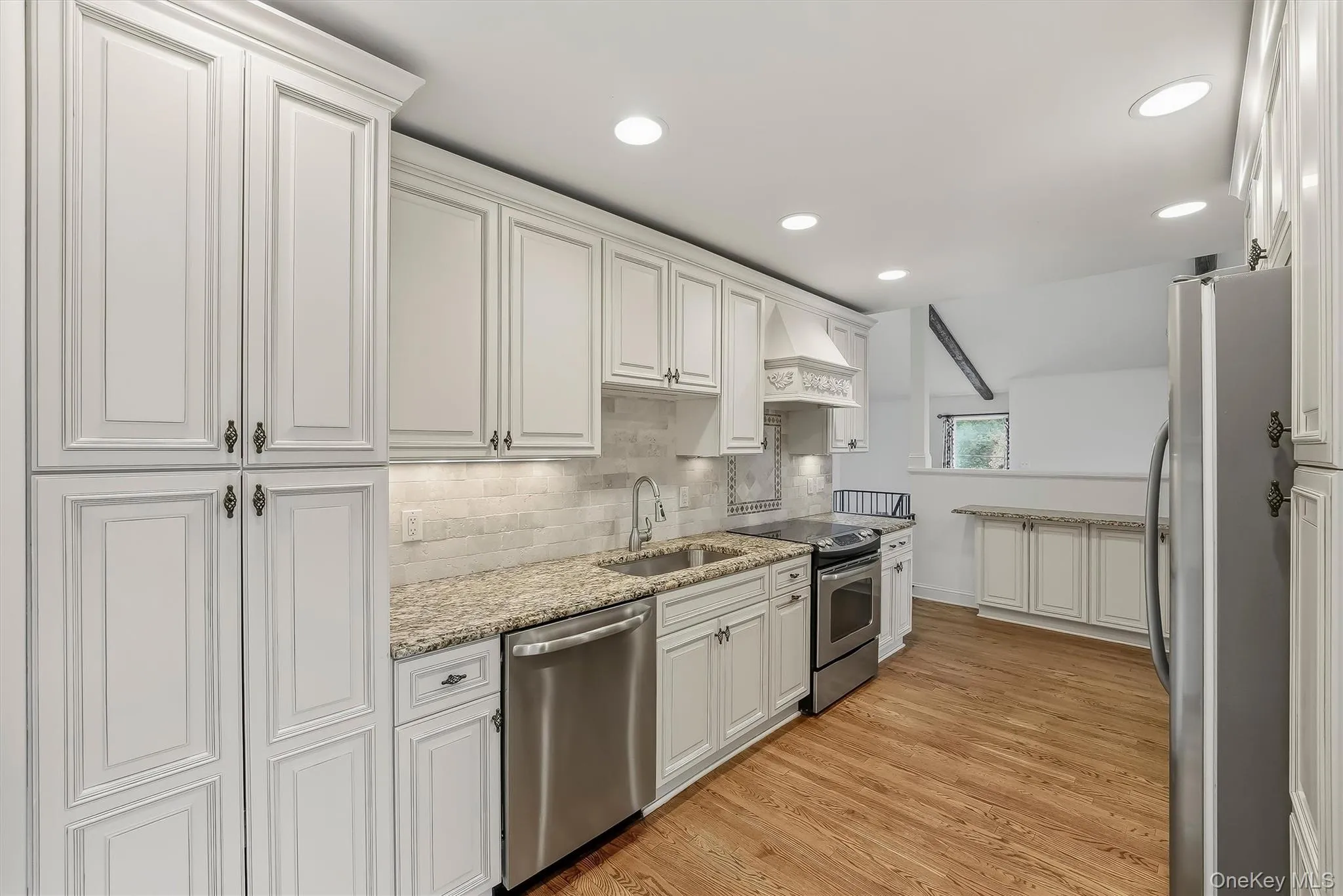 Elegant white kitchen w/ pantry, granite countertops, & custom cabinetry. Elegant white kitchen w/ pantry, granite countertops, & custom cabinetry.