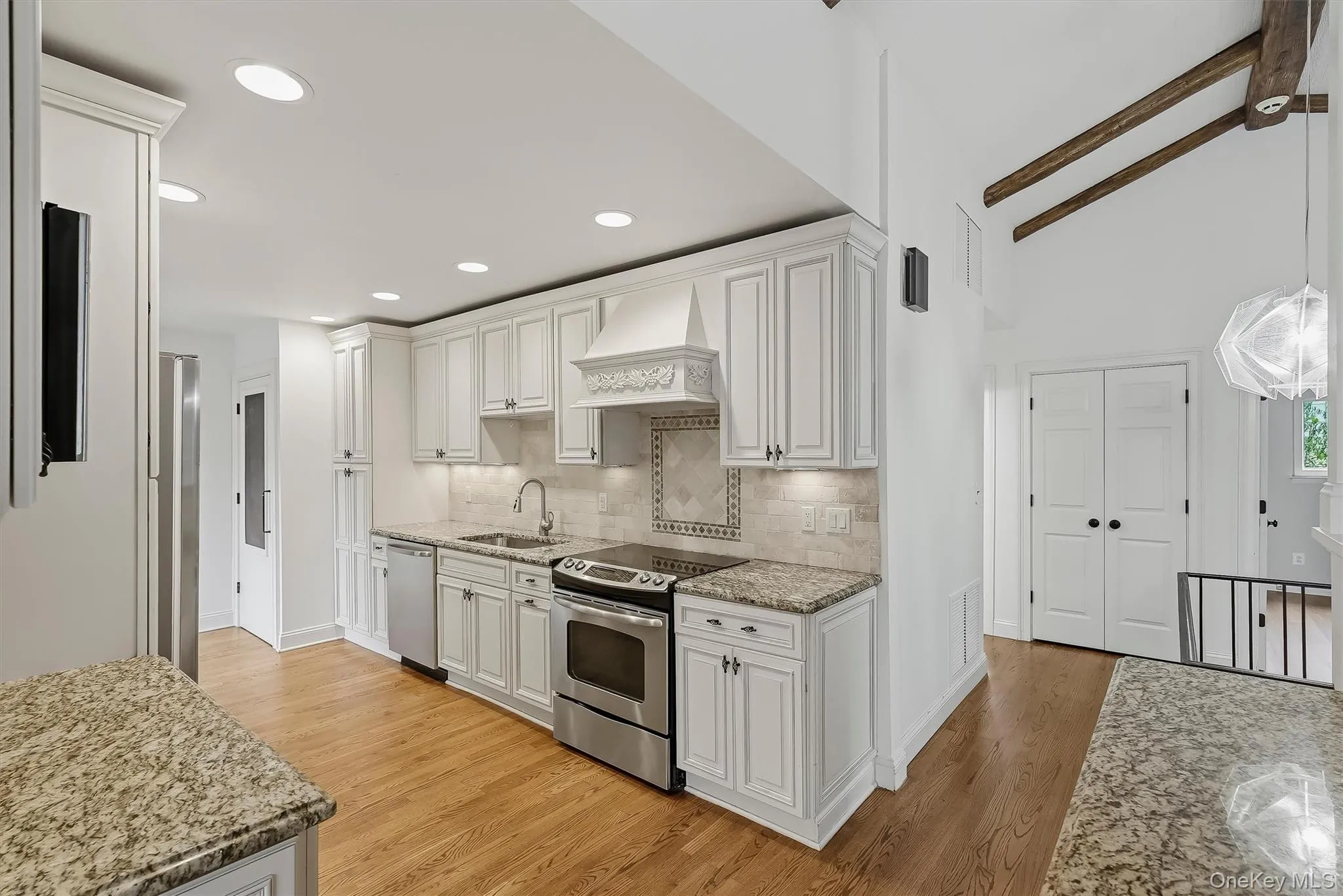 Elegant white kitchen w/ pantry, granite countertops, & custom cabinetry. Elegant white kitchen w/ pantry, granite countertops, & custom cabinetry.