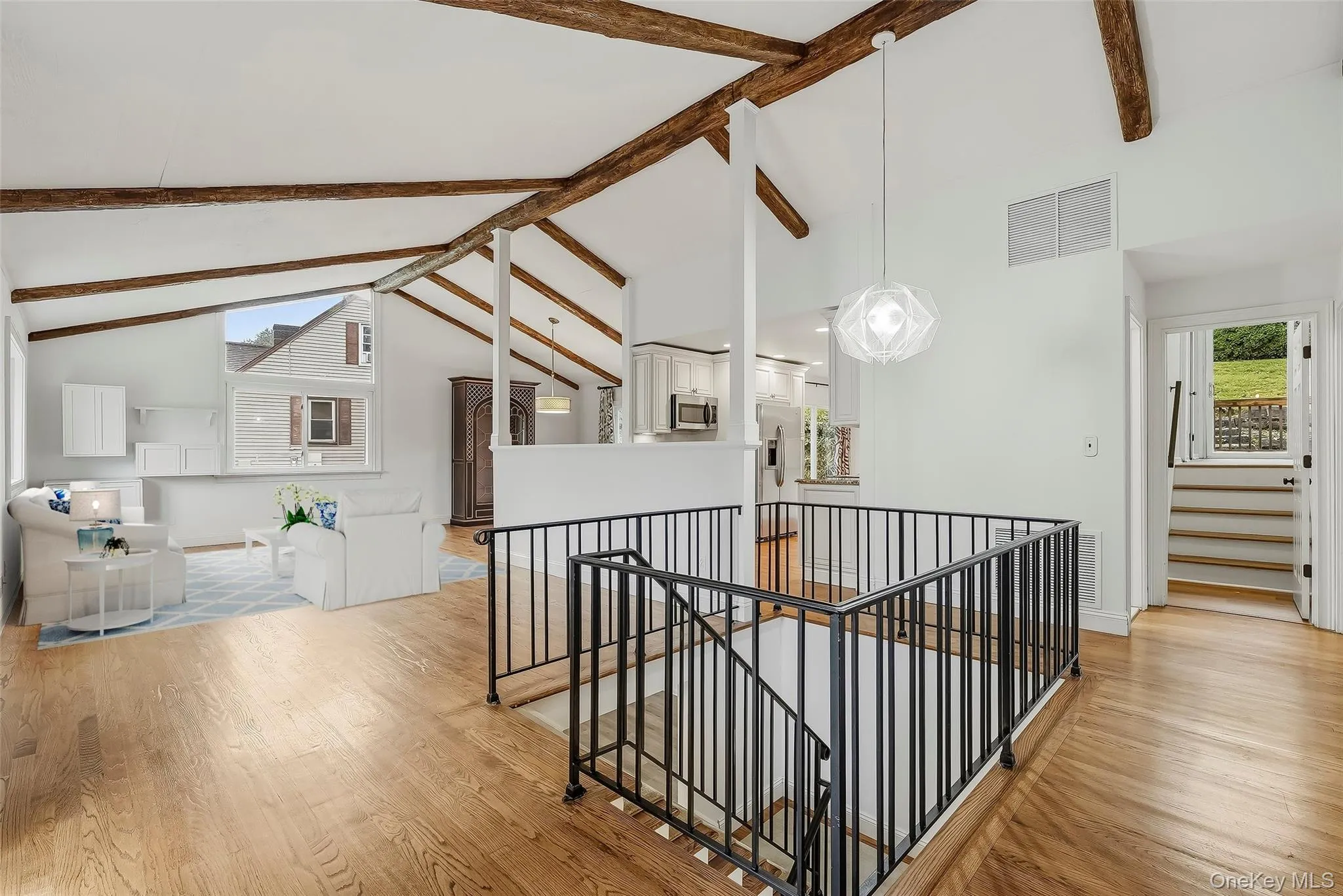 Open-plan great room w/ hardwood floors, exposed wood beams, and fresh paint. Open-plan great room w/ hardwood floors, exposed wood beams, and fresh paint.