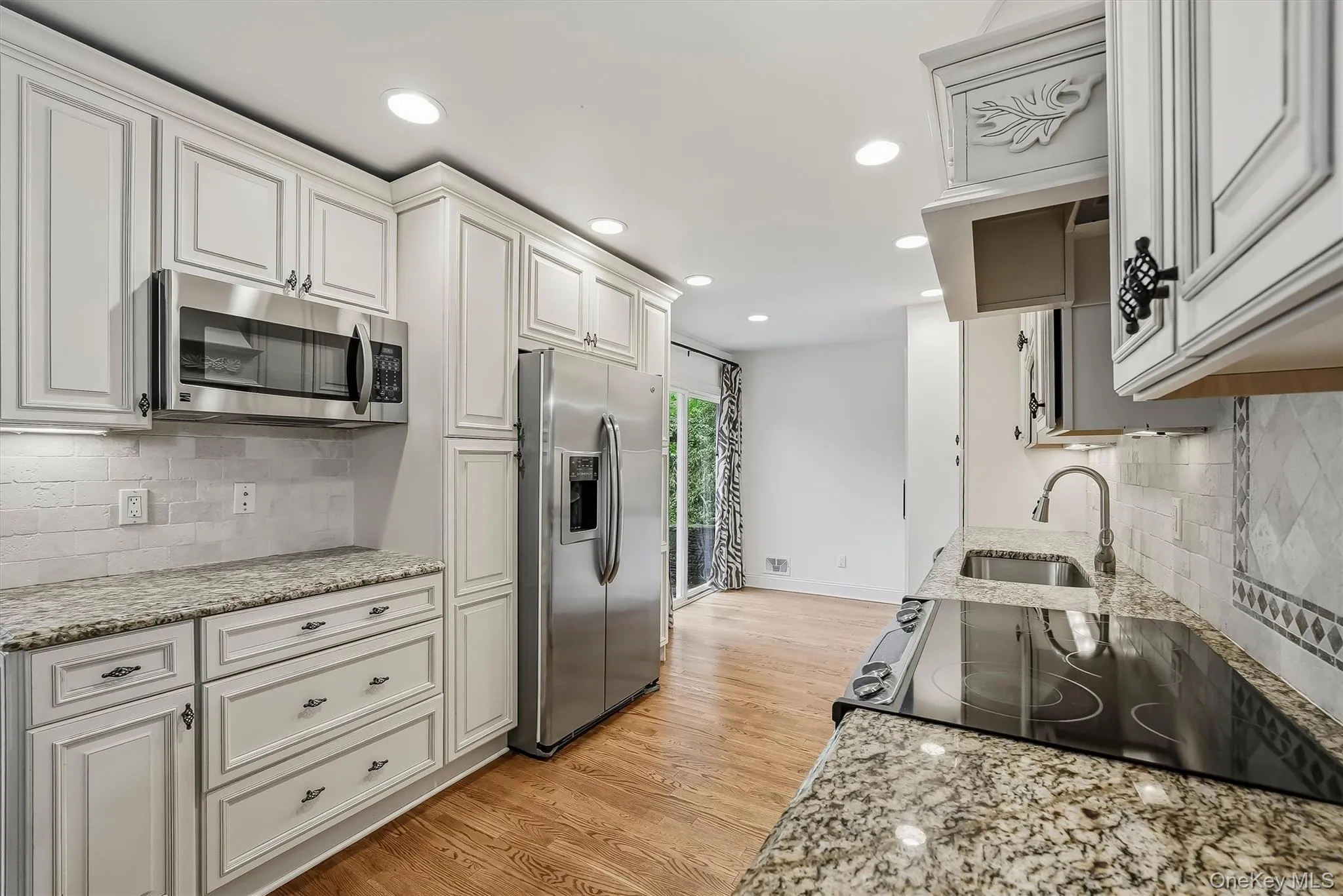 Elegant white kitchen w/ pantry, granite countertops, & custom cabinetry. Elegant white kitchen w/ pantry, granite countertops, & custom cabinetry.