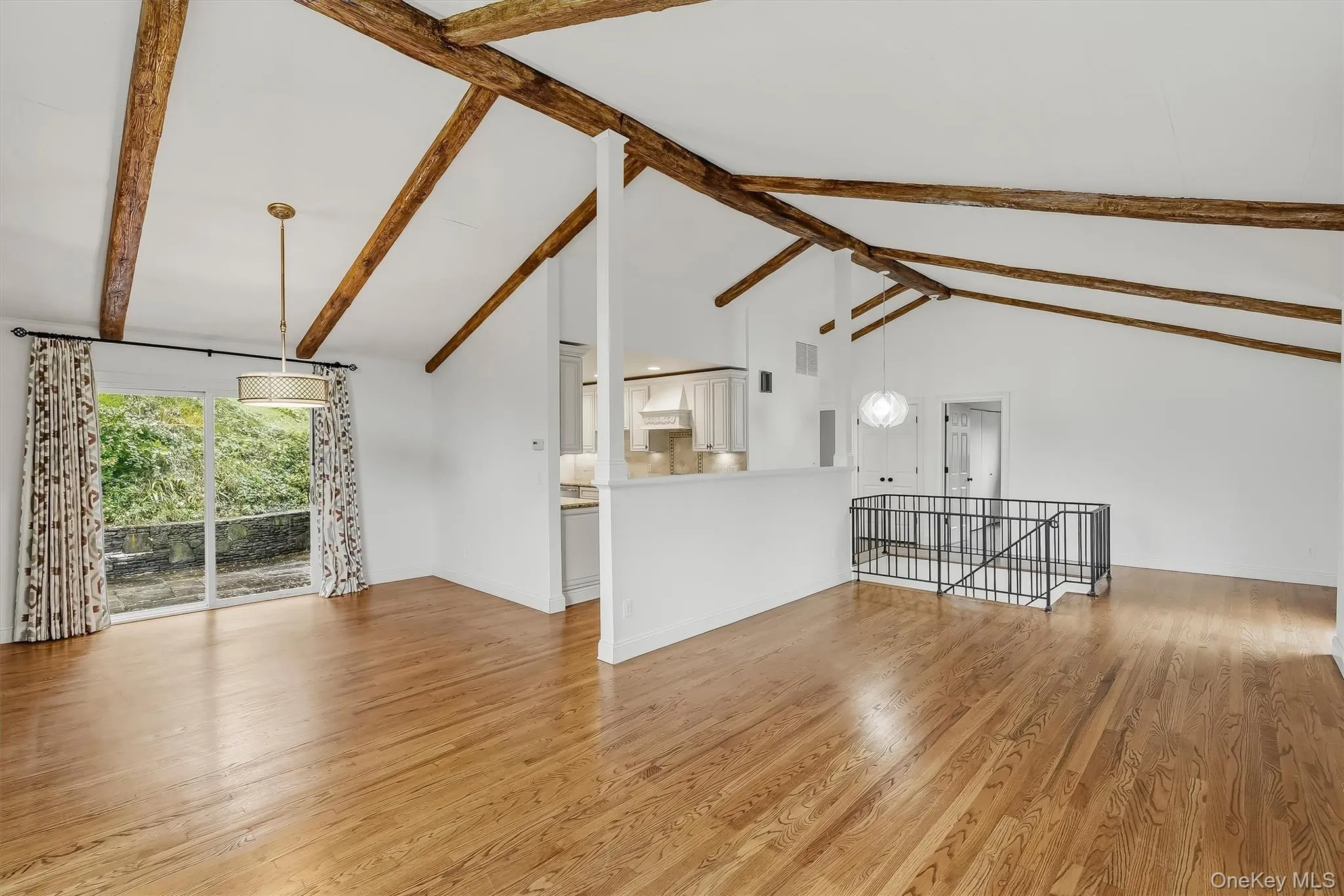 Open-plan great room w/ hardwood floors, exposed wood beams, and fresh paint. Open-plan great room w/ hardwood floors, exposed wood beams, and fresh paint.