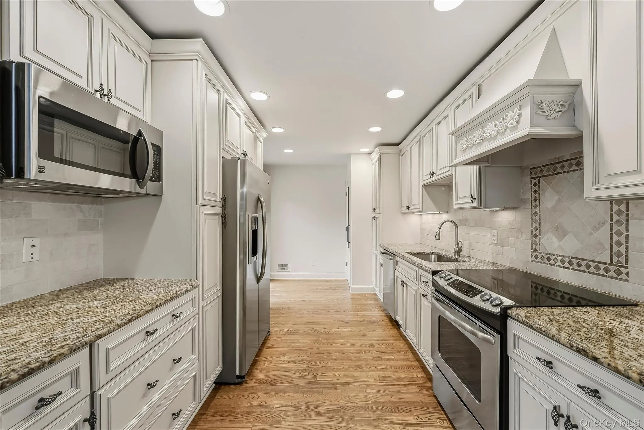 Elegant white kitchen w/ pantry, granite countertops, & custom cabinetry. Elegant white kitchen w/ pantry, granite countertops, & custom cabinetry.