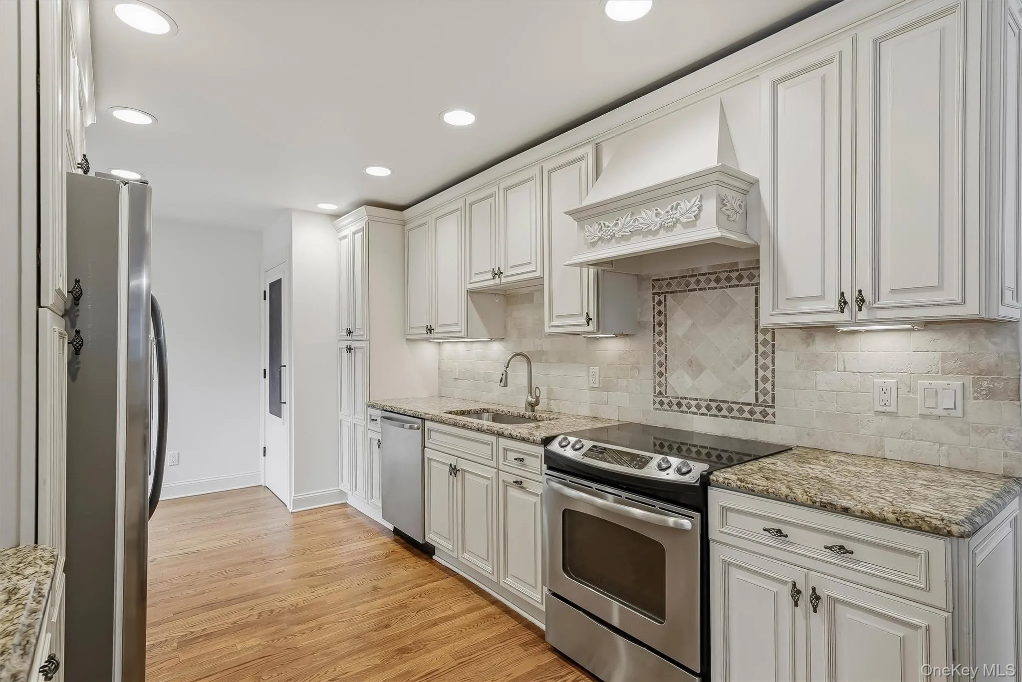 Elegant white kitchen w/ pantry, granite countertops, & custom cabinetry. Elegant white kitchen w/ pantry, granite countertops, & custom cabinetry.