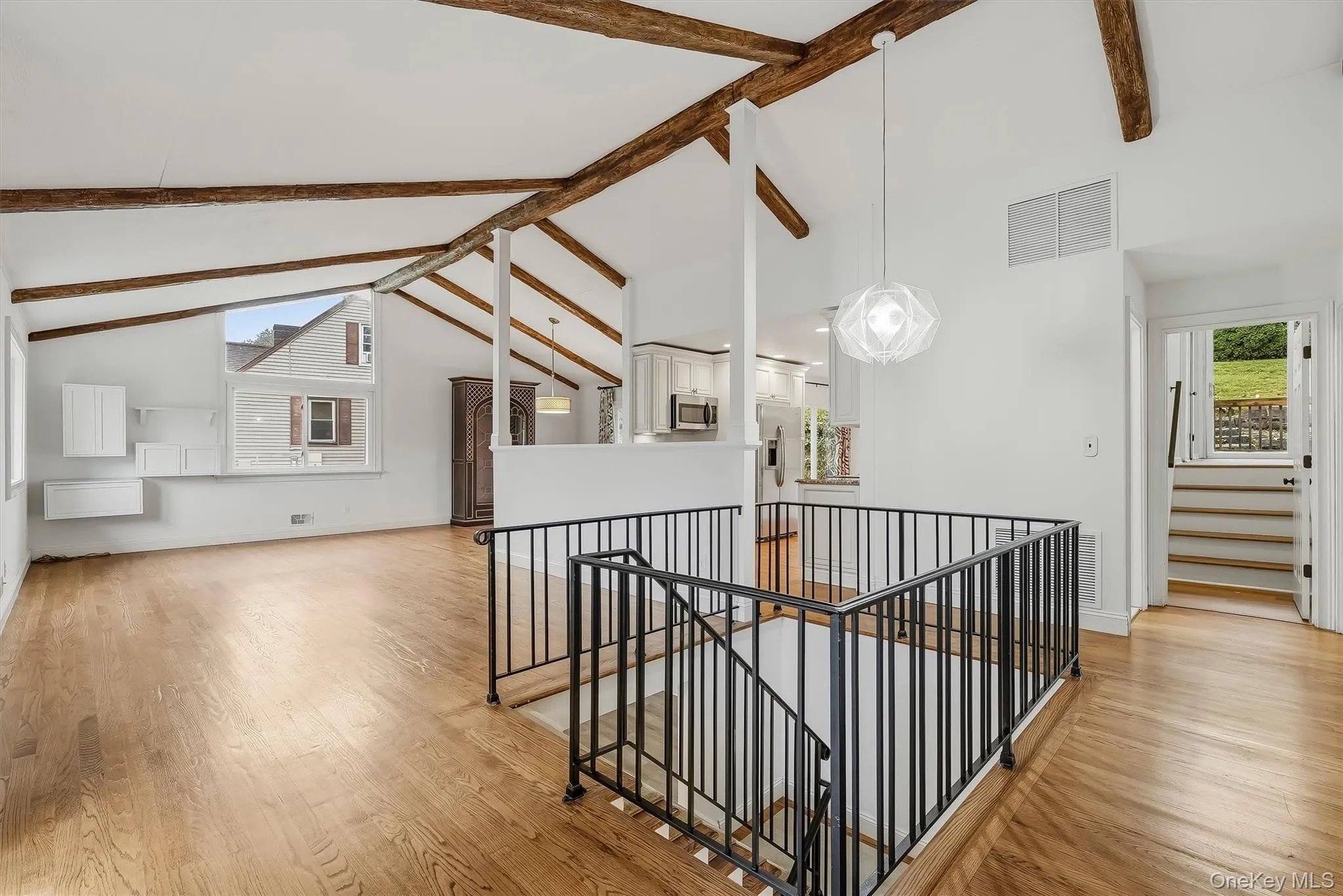 Open-plan great room w/ hardwood floors, exposed wood beams, and fresh paint. Open-plan great room w/ hardwood floors, exposed wood beams, and fresh paint.