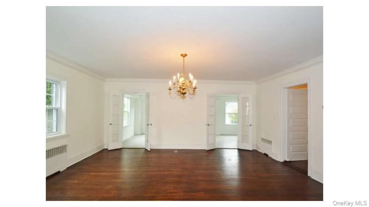 Hardwood flooring, dual pane windows, classic chandelier, crown molding, and white trim Hardwood flooring, dual pane windows, classic chandelier, crown molding, and white trim