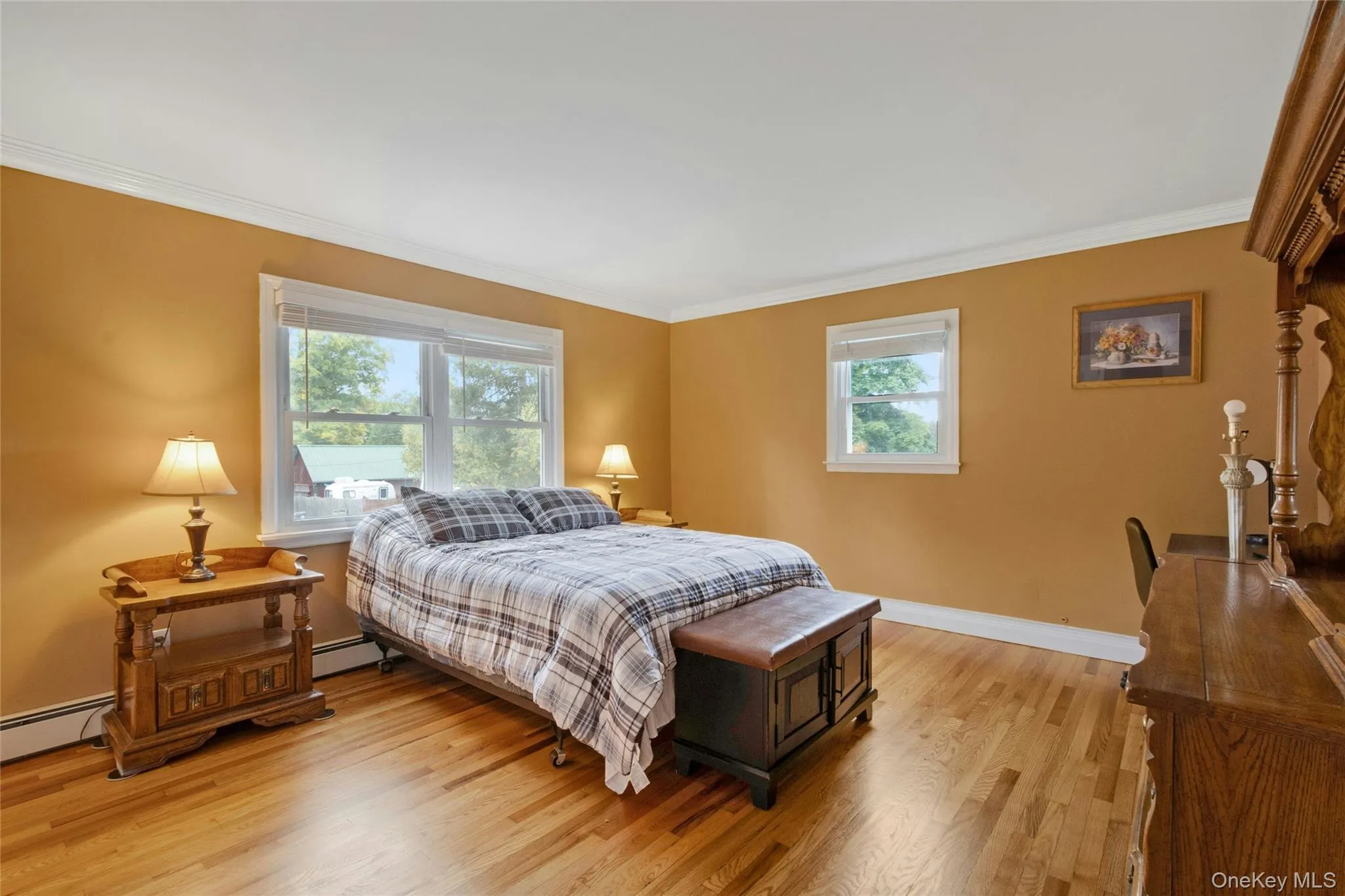 Hardwood flooring, painted walls, crown molding, and multiple windows Hardwood flooring, painted walls, crown molding, and multiple windows