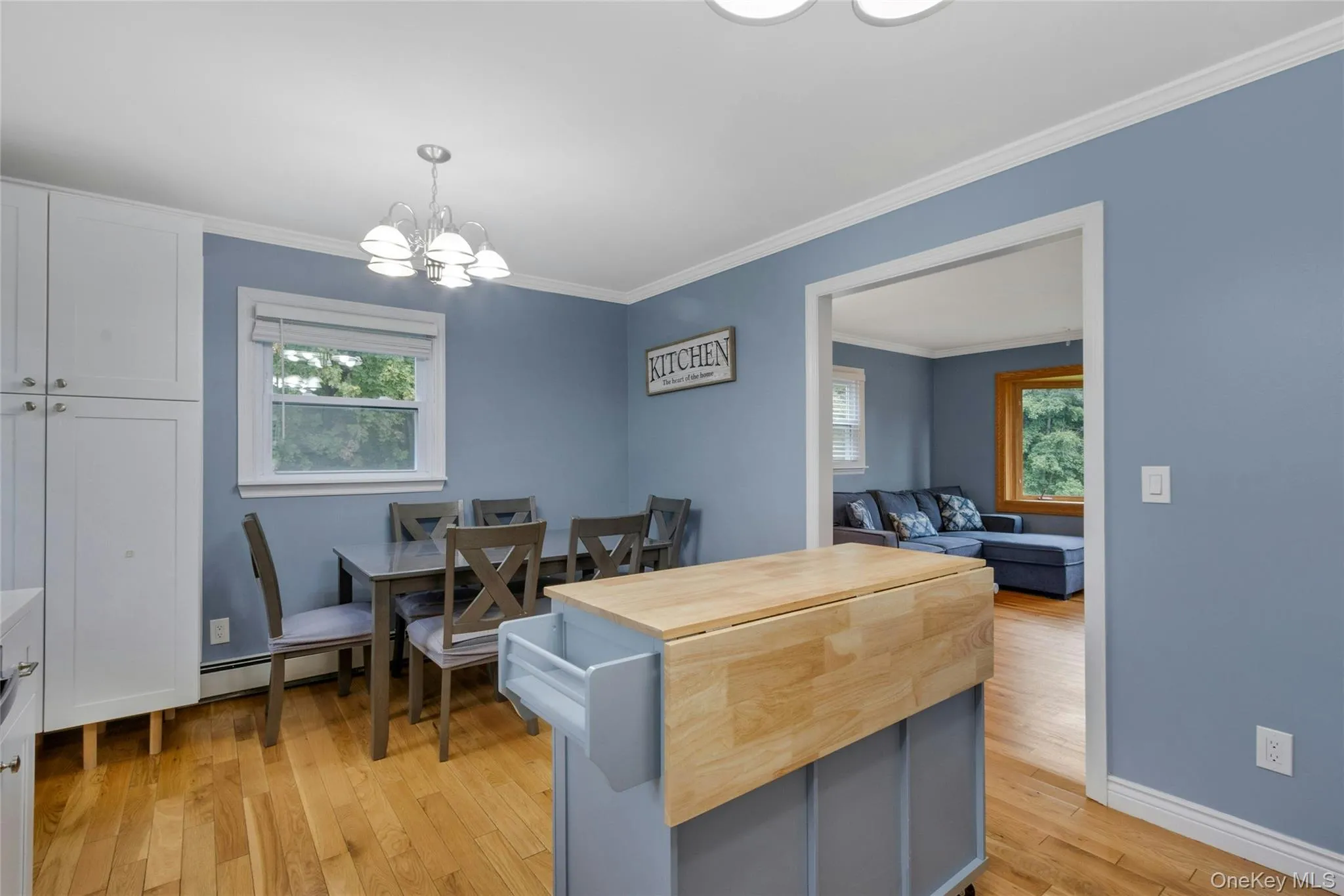 Hardwood flooring, crown molding, white trim, recessed window, and a built-in pantry cabinet Hardwood flooring, crown molding, white trim, recessed window, and a built-in pantry cabinet