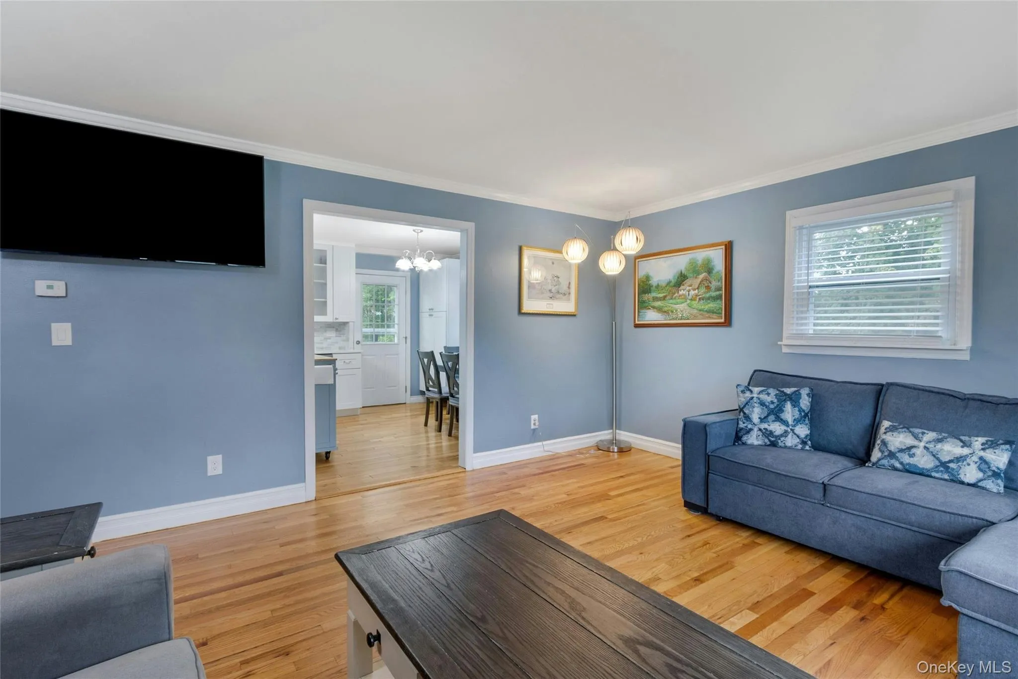 Hardwood flooring, painted walls, crown molding, and a window with blinds Hardwood flooring, painted walls, crown molding, and a window with blinds