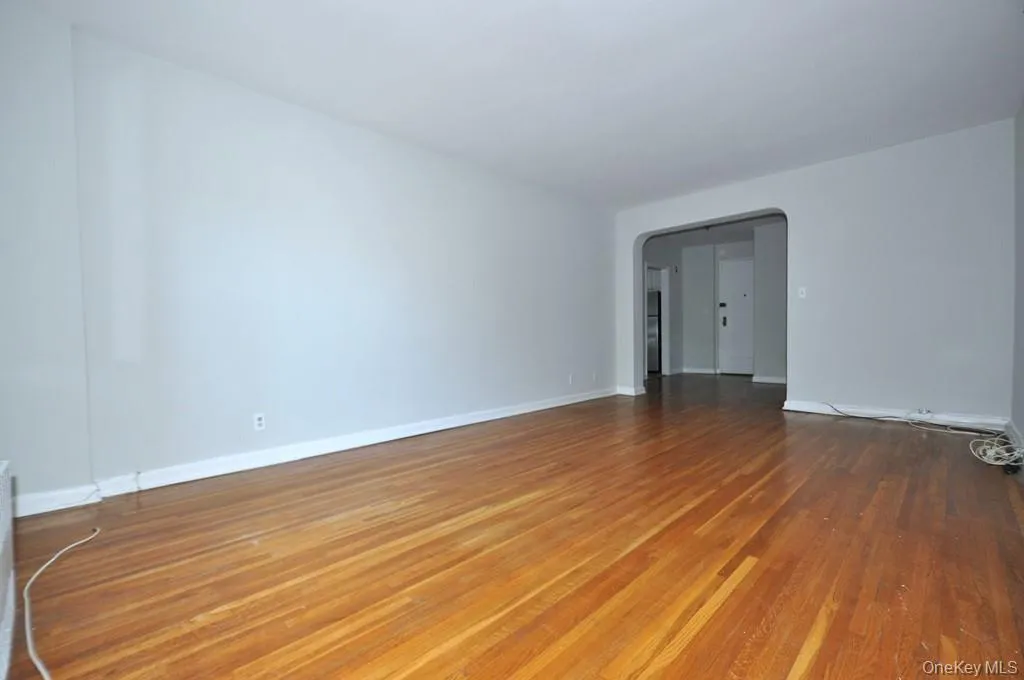 Large Corner Living Room with Hardwood floors opens to the dining foyer and overlooking Tree Lined Garth Road. The living room is 19'-10" x 12'-2". Large Corner Living Room with Hardwood floors opens to the dining foyer and overlooking Tree Lined Garth Road. The living room is 19'-10" x 12'-2".
