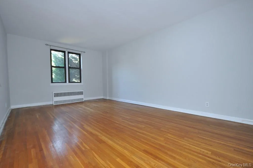 Large Corner Living Room with Hardwood floors opens to the dining foyer and overlooking Tree Lined Garth Road. The living room is 19'-10" x 12'-2". Large Corner Living Room with Hardwood floors opens to the dining foyer and overlooking Tree Lined Garth Road. The living room is 19'-10" x 12'-2".