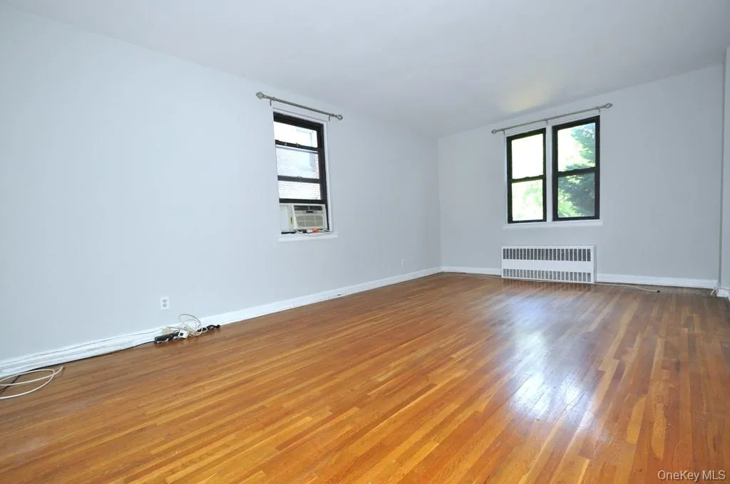 Large Corner Living Room with Hardwood floors opens to the dining foyer and overlooking Tree Lined Garth Road. The living room is 19'-10" x 12'-2". Large Corner Living Room with Hardwood floors opens to the dining foyer and overlooking Tree Lined Garth Road. The living room is 19'-10" x 12'-2".