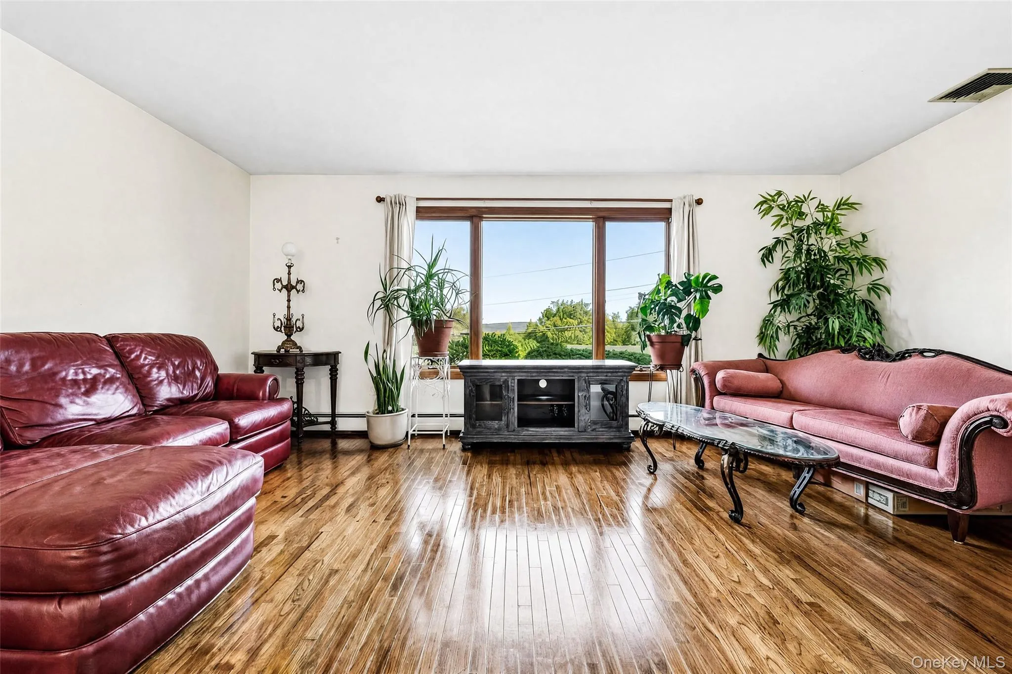 Wood flooring, framed window with natural light, and ample wall space Wood flooring, framed window with natural light, and ample wall space