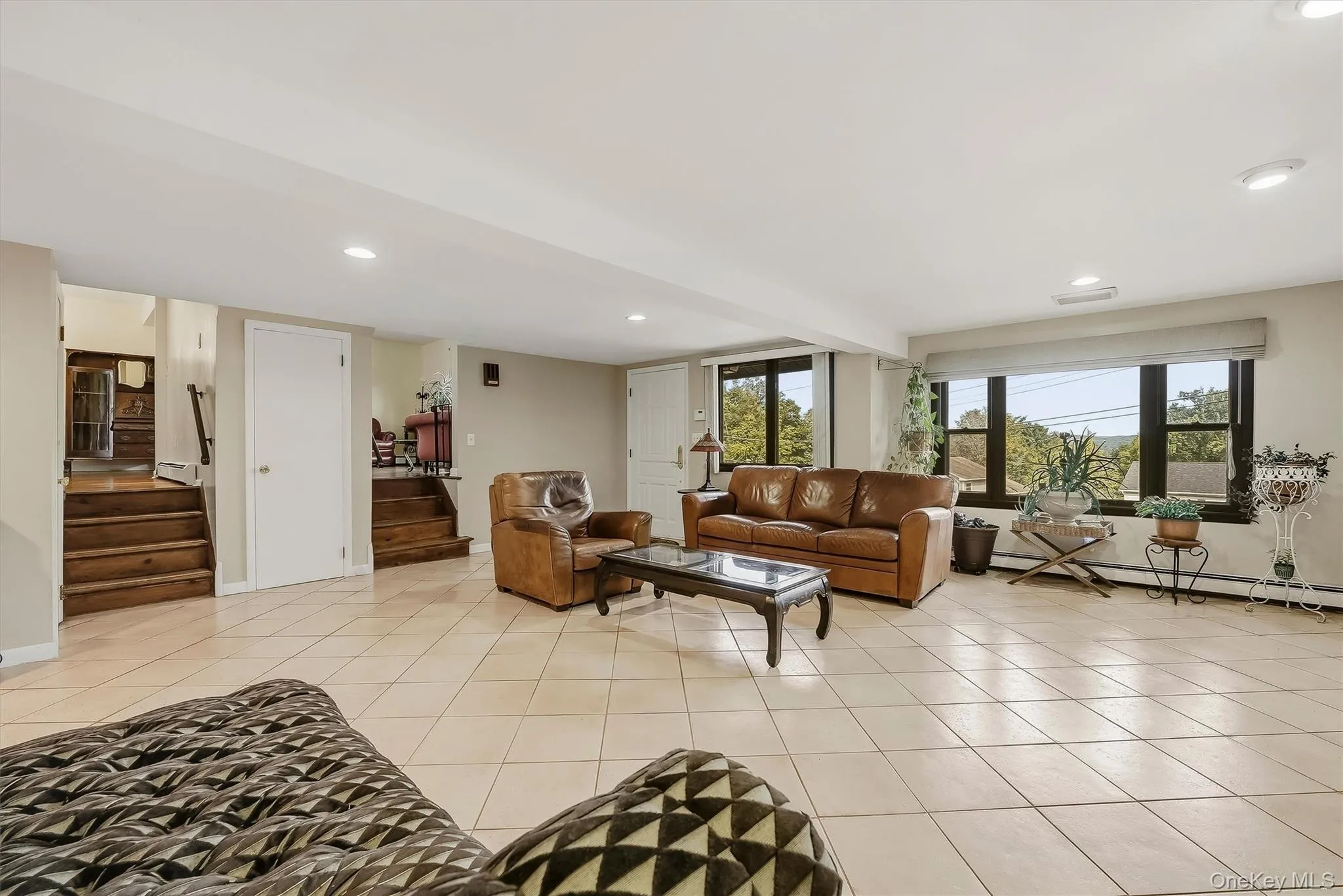 Spacious 1st level recreation room with large windows, recessed lighting, and light-toned tile flooring Spacious 1st level recreation room with large windows, recessed lighting, and light-toned tile flooring