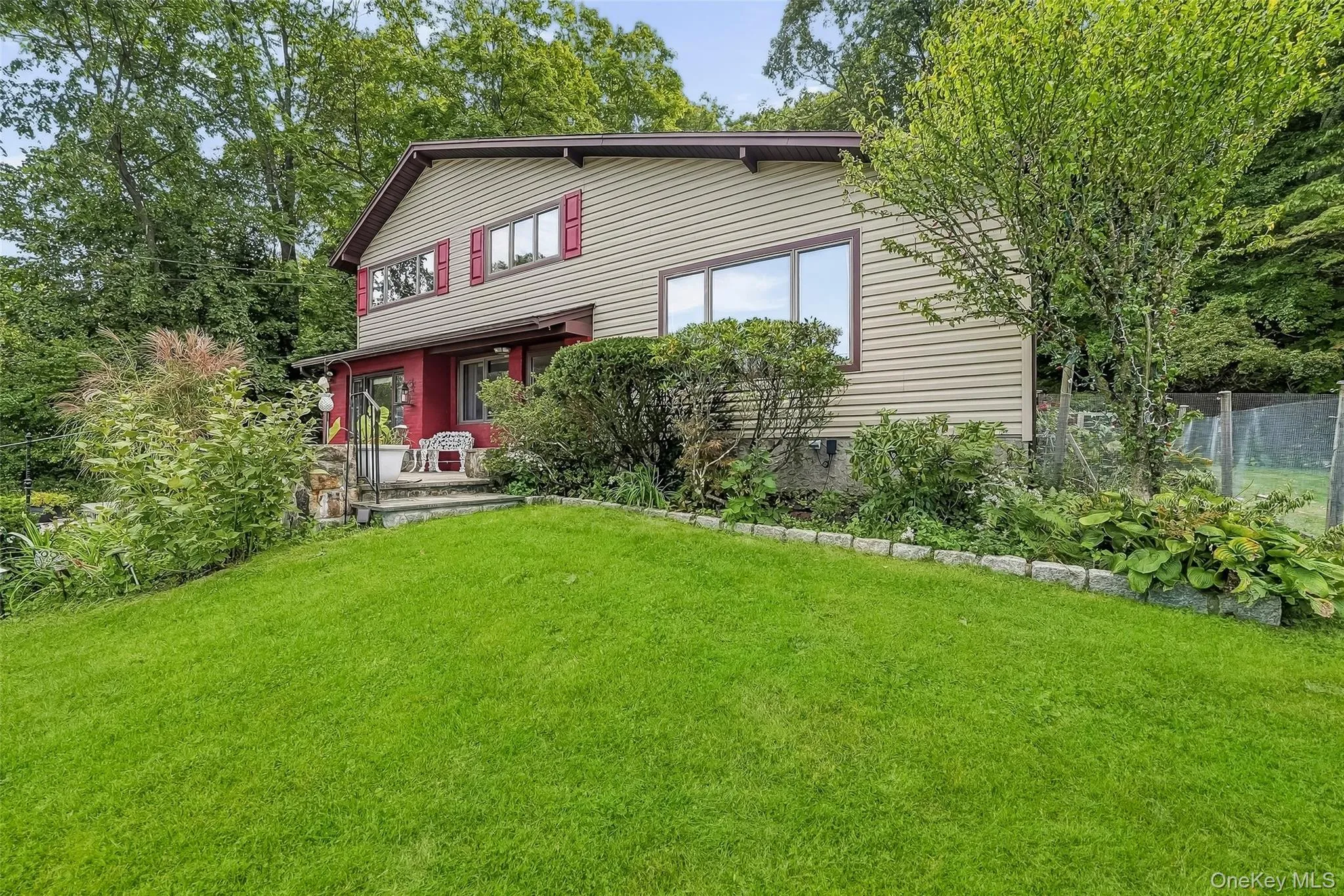 Split-level residence with red shutters, and a covered entry. Split-level residence with red shutters, and a covered entry.