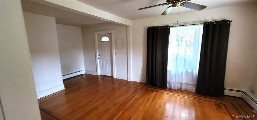 hardwood / wood-style flooring, a baseboard heating unit, and ceiling fan, egress exit (front door) hardwood / wood-style flooring, a baseboard heating unit, and ceiling fan, egress exit (front door)