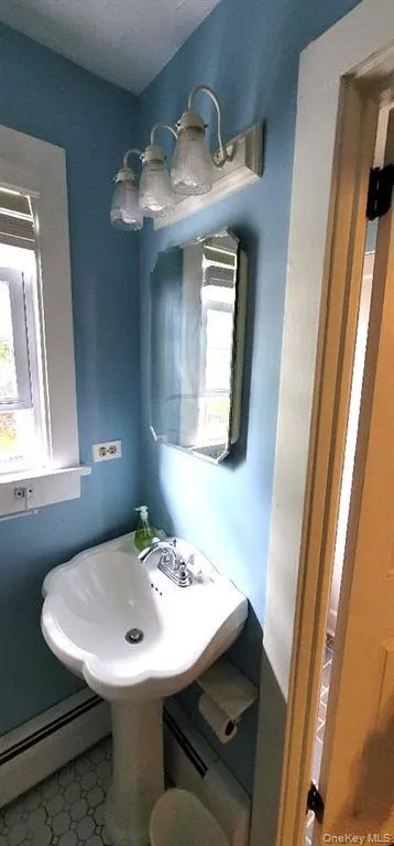 Bathroom featuring tile patterned floors and baseboard heating Bathroom featuring tile patterned floors and baseboard heating