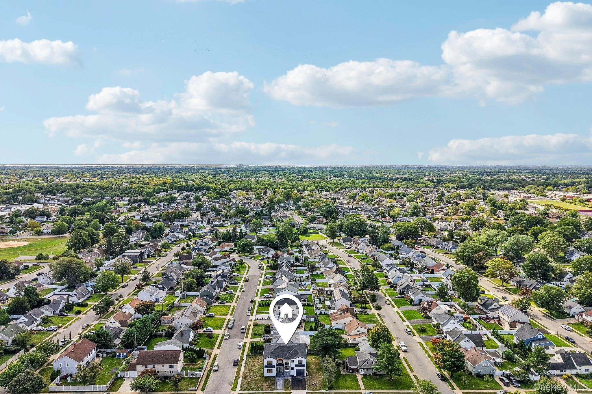 Expansive residential area featuring numerous single-family homes, mature trees lining streets, and visible athletic fields Expansive residential area featuring numerous single-family homes, mature trees lining streets, and visible athletic fields