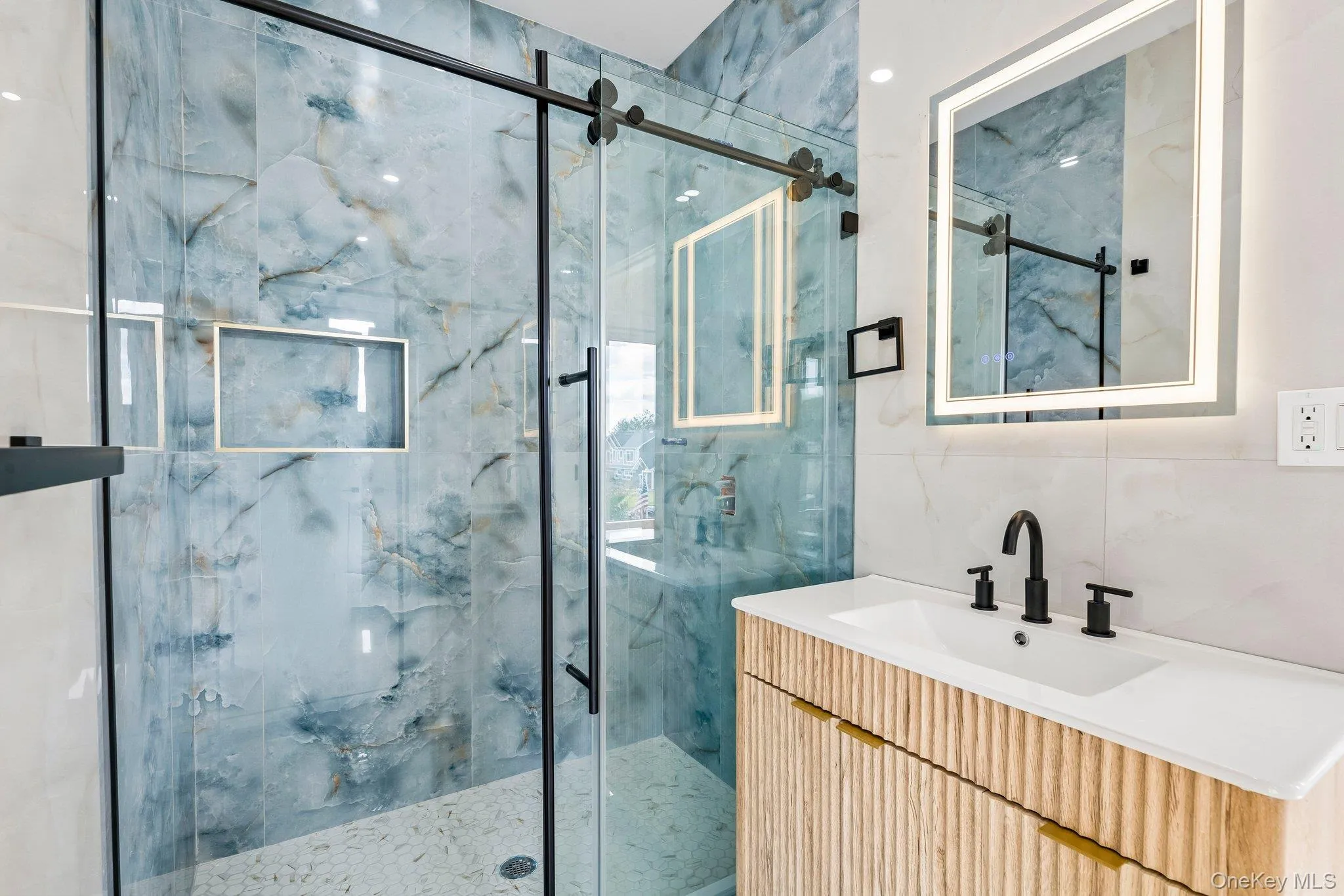 Shower with blue marble-effect tile and sliding glass door Shower with blue marble-effect tile and sliding glass door