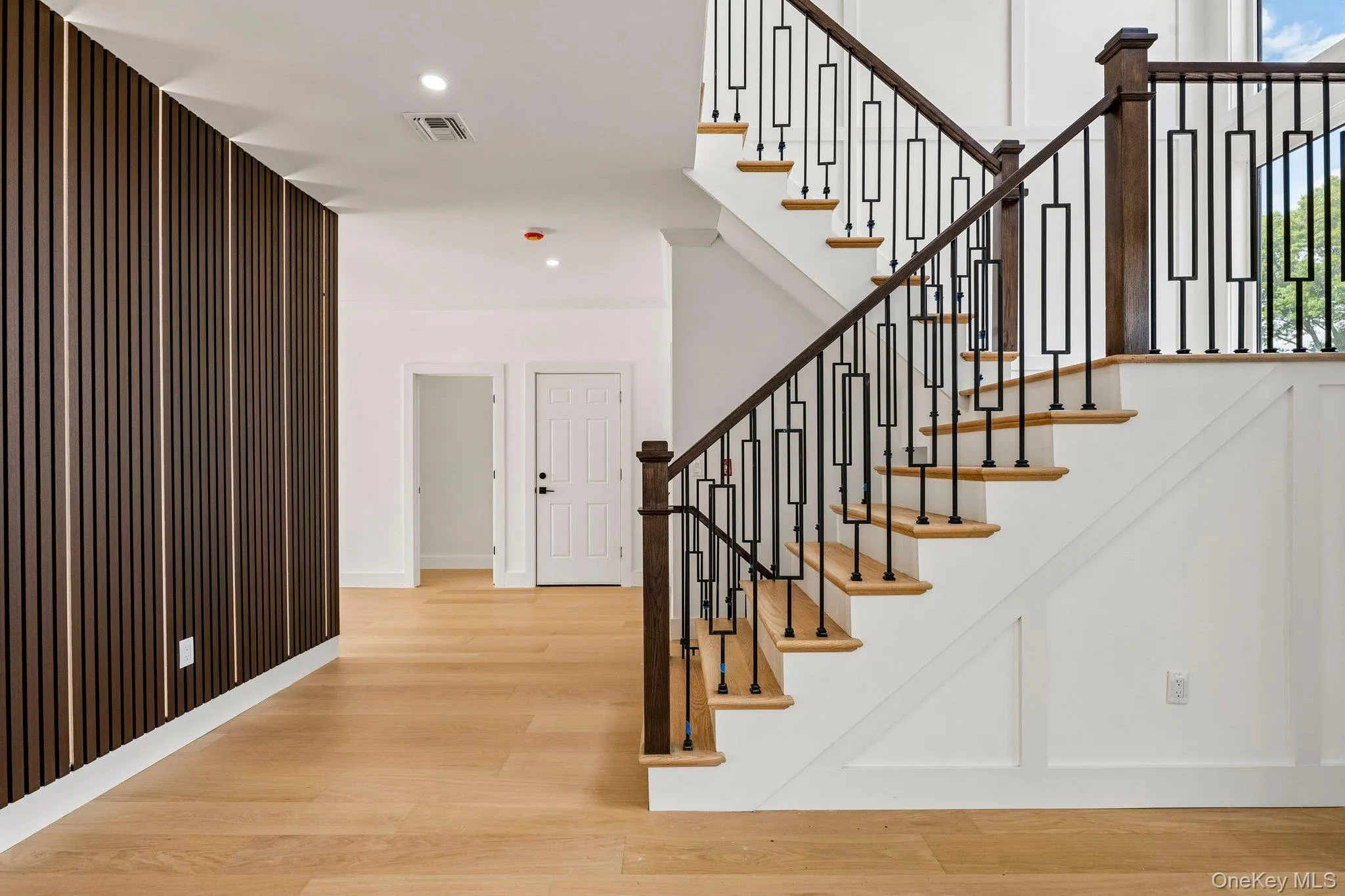 Hardwood flooring with a modern wood slat accent wall Hardwood flooring with a modern wood slat accent wall