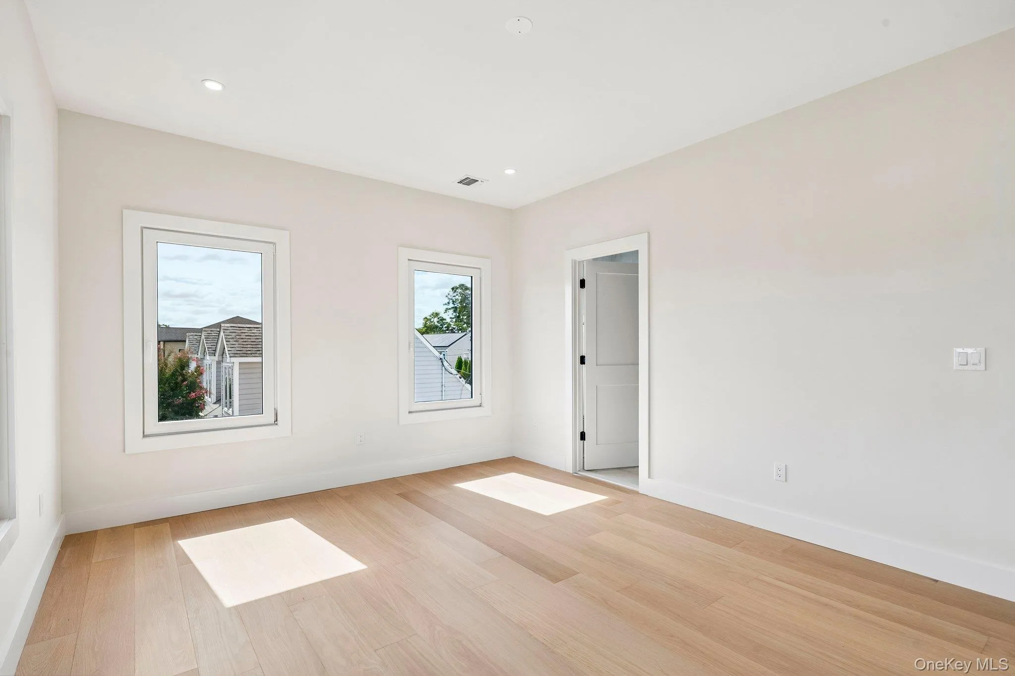Recessed lighting, light wood-finish flooring, white trim, and two pane windows Recessed lighting, light wood-finish flooring, white trim, and two pane windows