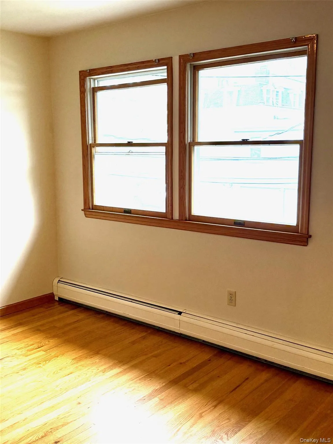 Spare room with a baseboard radiator and light wood-type flooring Spare room with a baseboard radiator and light wood-type flooring