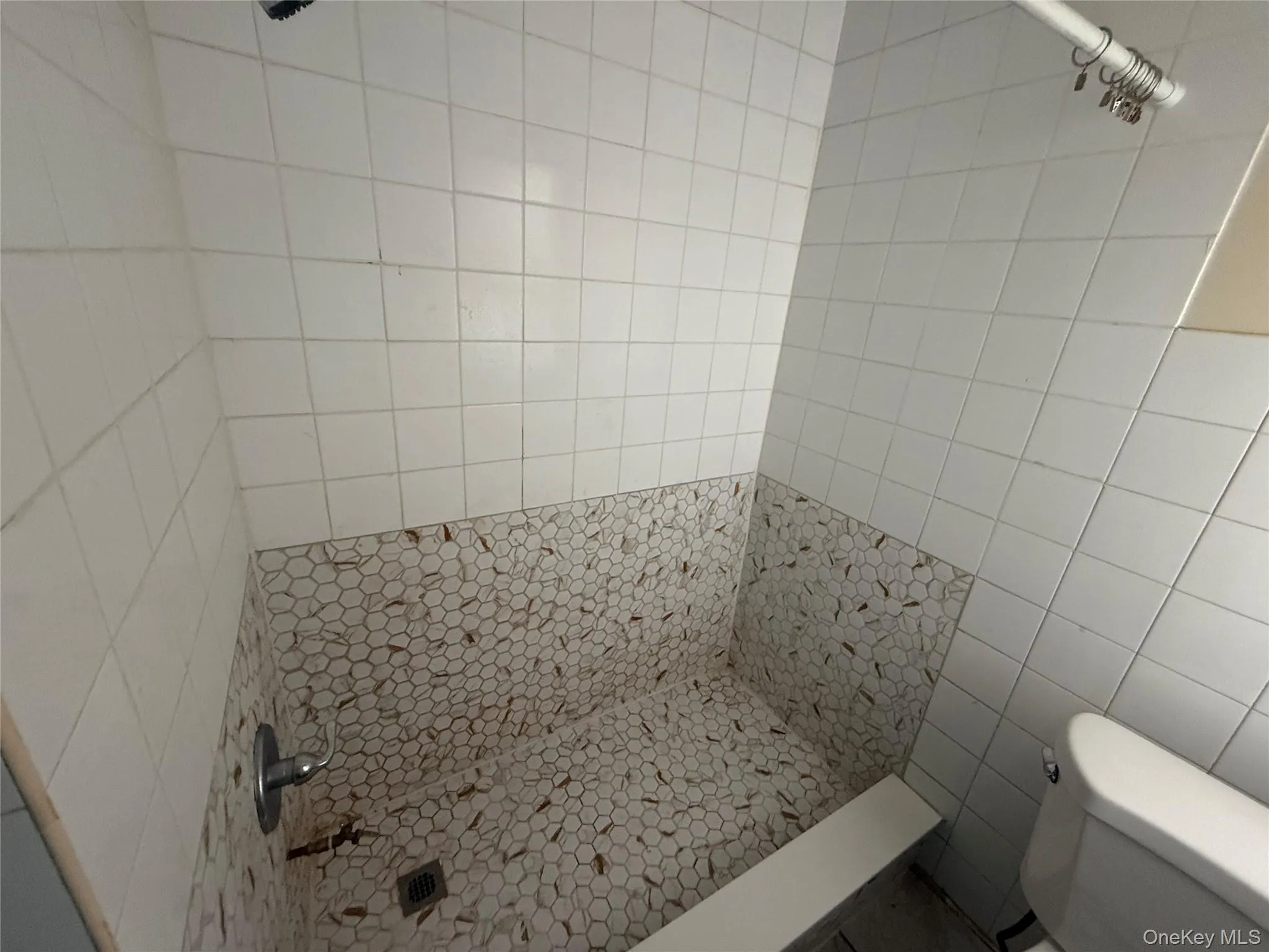 Bathroom with a shower stall and tile walls Bathroom with a shower stall and tile walls