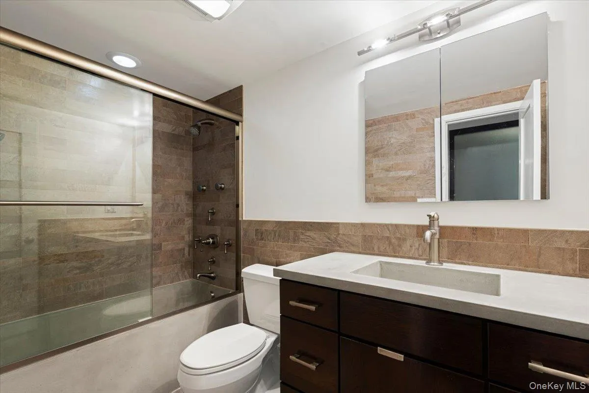 Modern Bathroom featuring bath/shower combo with glass doors Modern Bathroom featuring bath/shower combo with glass doors