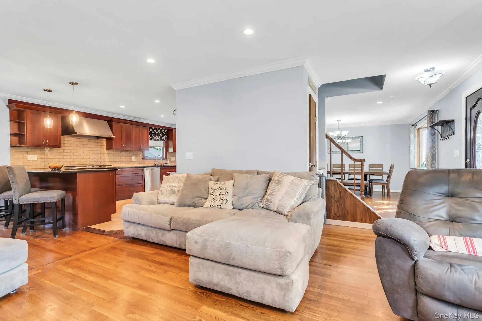 Hardwood flooring, recessed lighting, crown molding, stainless steel appliances, and a tiled kitchen backsplash Hardwood flooring, recessed lighting, crown molding, stainless steel appliances, and a tiled kitchen backsplash
