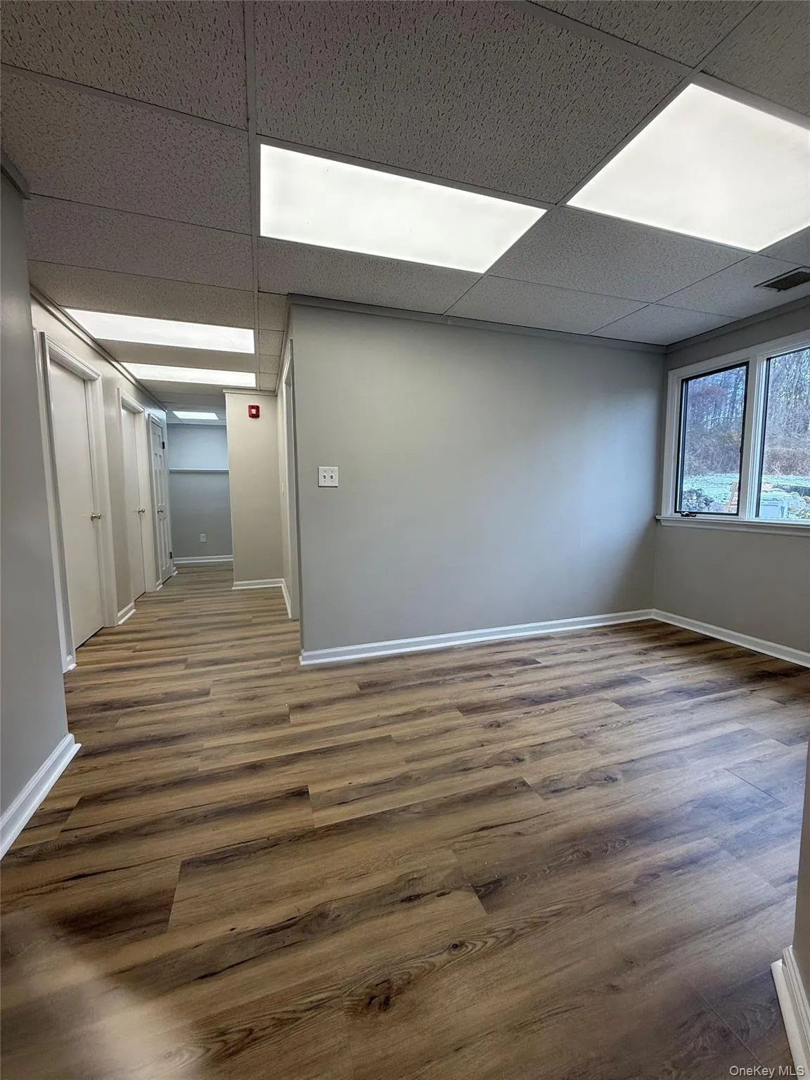 Empty room featuring wood finished floors and a paneled ceiling Empty room featuring wood finished floors and a paneled ceiling