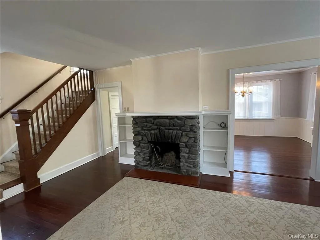 Living room featuring fireplace, dark hardwood floors, molding and access to kitchen and dining room Living room featuring fireplace, dark hardwood floors, molding and access to kitchen and dining room