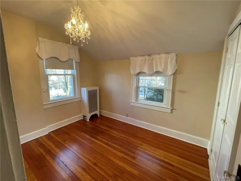 Bedroom 3 featuring hardwood floors, closet space and chandelier. Bedroom 3 featuring hardwood floors, closet space and chandelier.