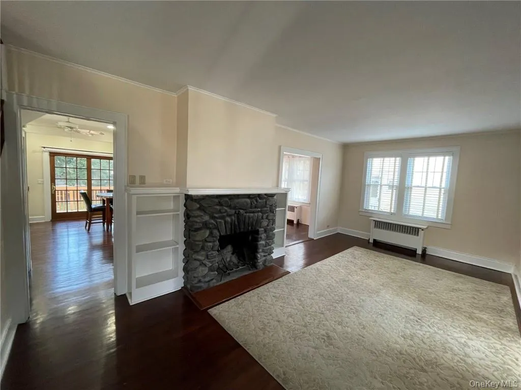 Living room featuring fireplace, dark hardwood floors, molding and access to kitchen and dining room Living room featuring fireplace, dark hardwood floors, molding and access to kitchen and dining room